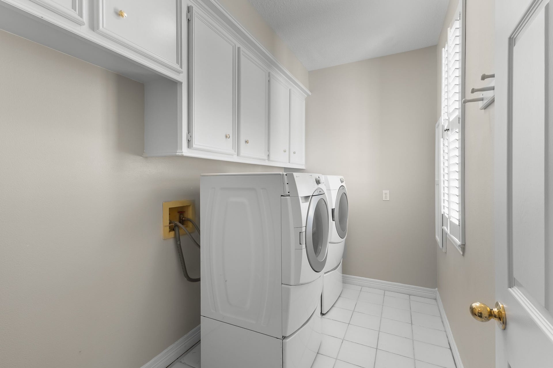 A dedicated laundry area with overhead cabinetry keeps household essentials organized and close at hand. [Washer and Dryer are included]