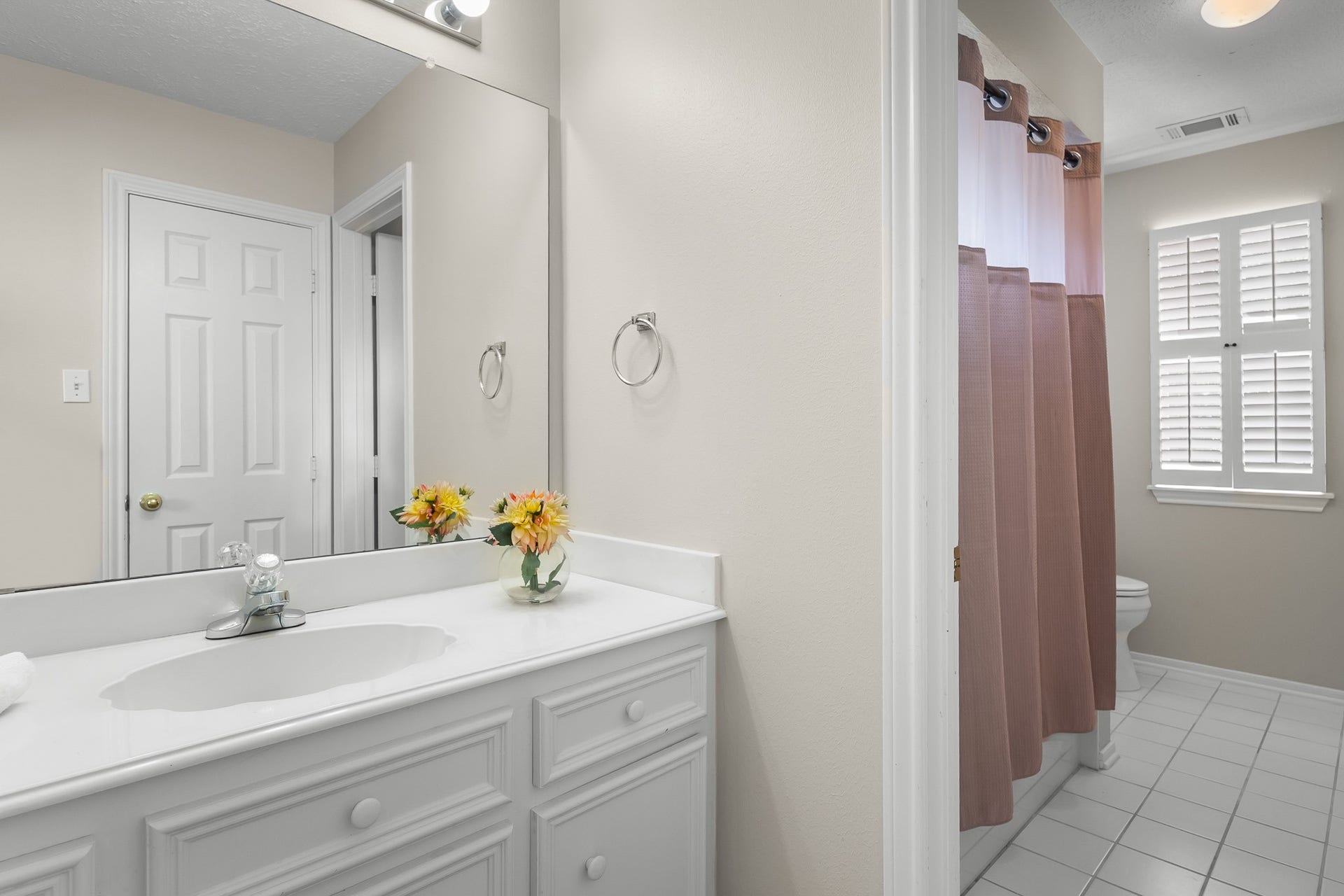 16314 Graven Hill Drive, Spring, TX 77379 A bright bathroom pairs a white vanity with a tub-shower combination and timeless neutral finishes.