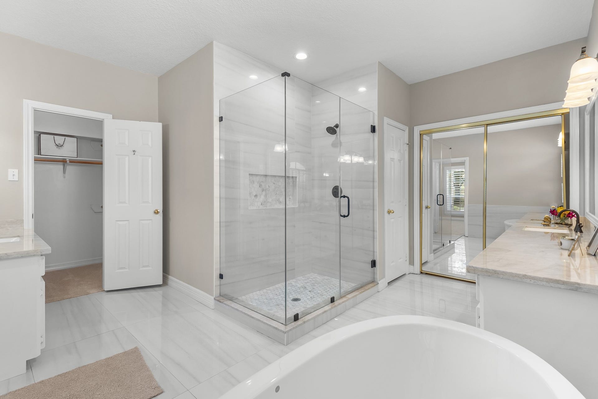 16314 Graven Hill Drive, Spring, TX 77379 A glass-enclosed shower and separate soaking tub create a polished bathing space, complemented by bright finishes and generous natural light.
