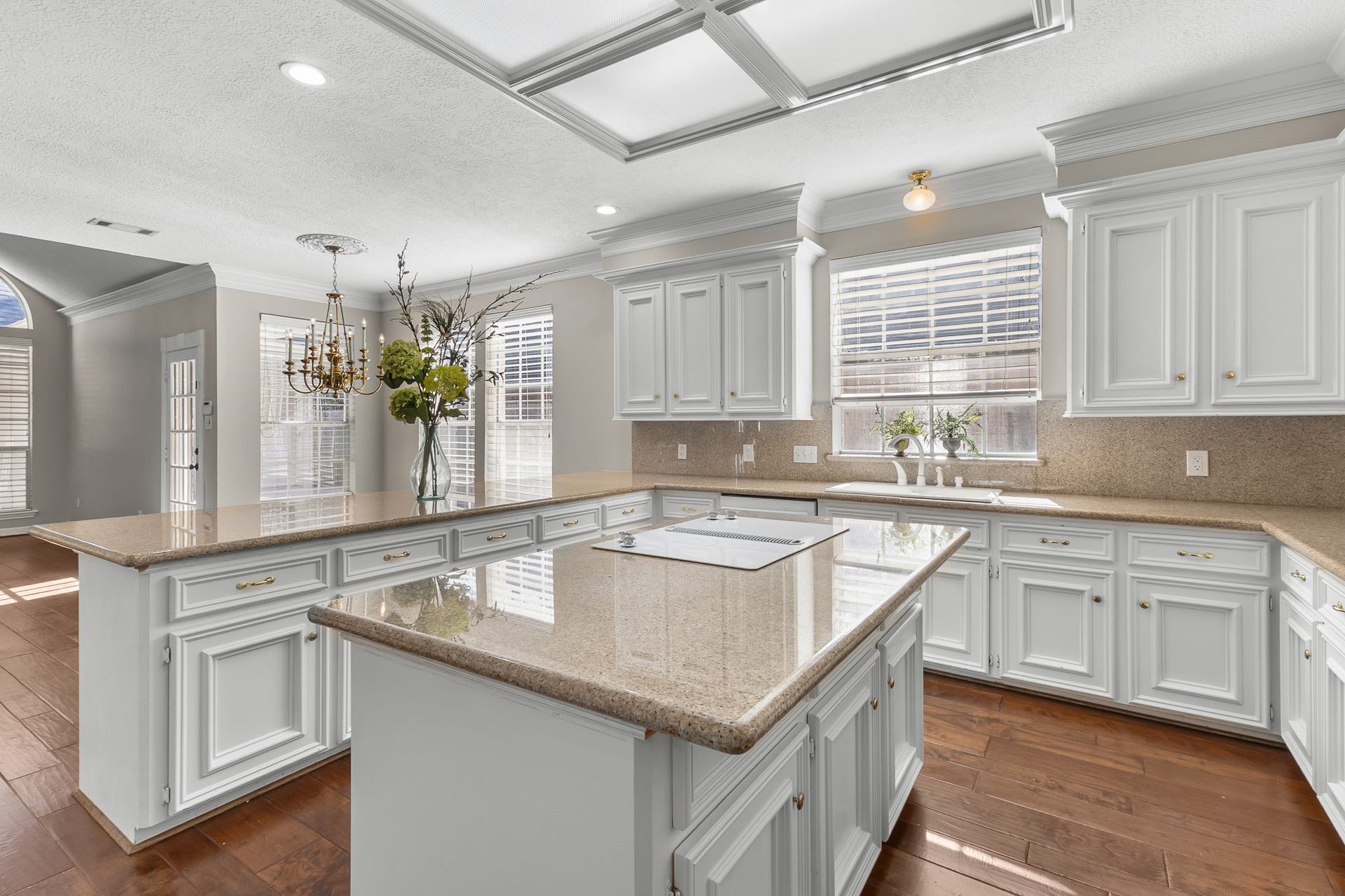 16314 Graven Hill Drive, Spring, TX 77379 White cabinetry, generous granite work surfaces and a central island define a bright kitchen with classic appeal and abundant workspace.