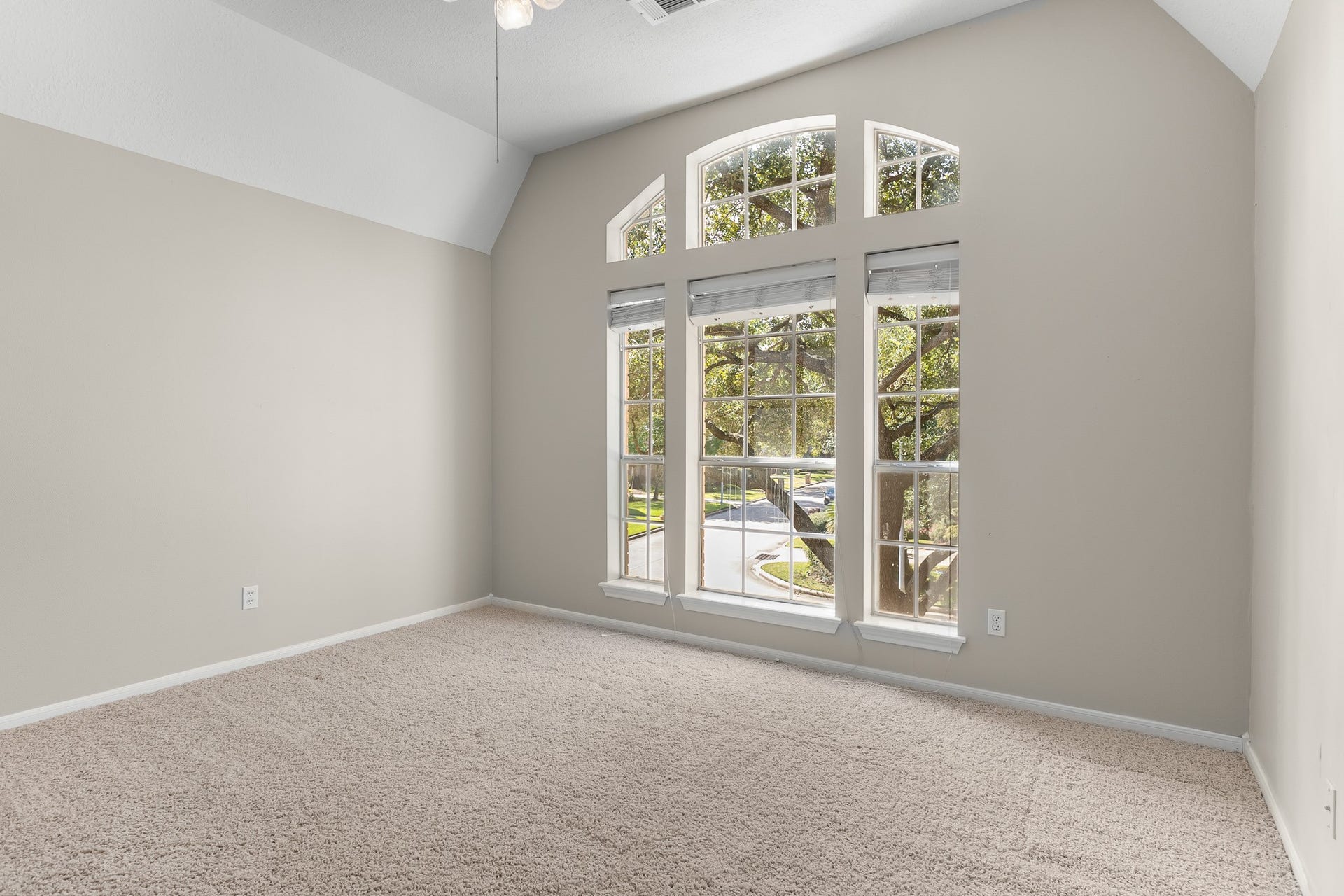 16314 Graven Hill Drive, Spring, TX 77379 An arched window and vaulted ceiling lend architectural interest to this spacious bedroom, enhanced by soft neutral finishes.