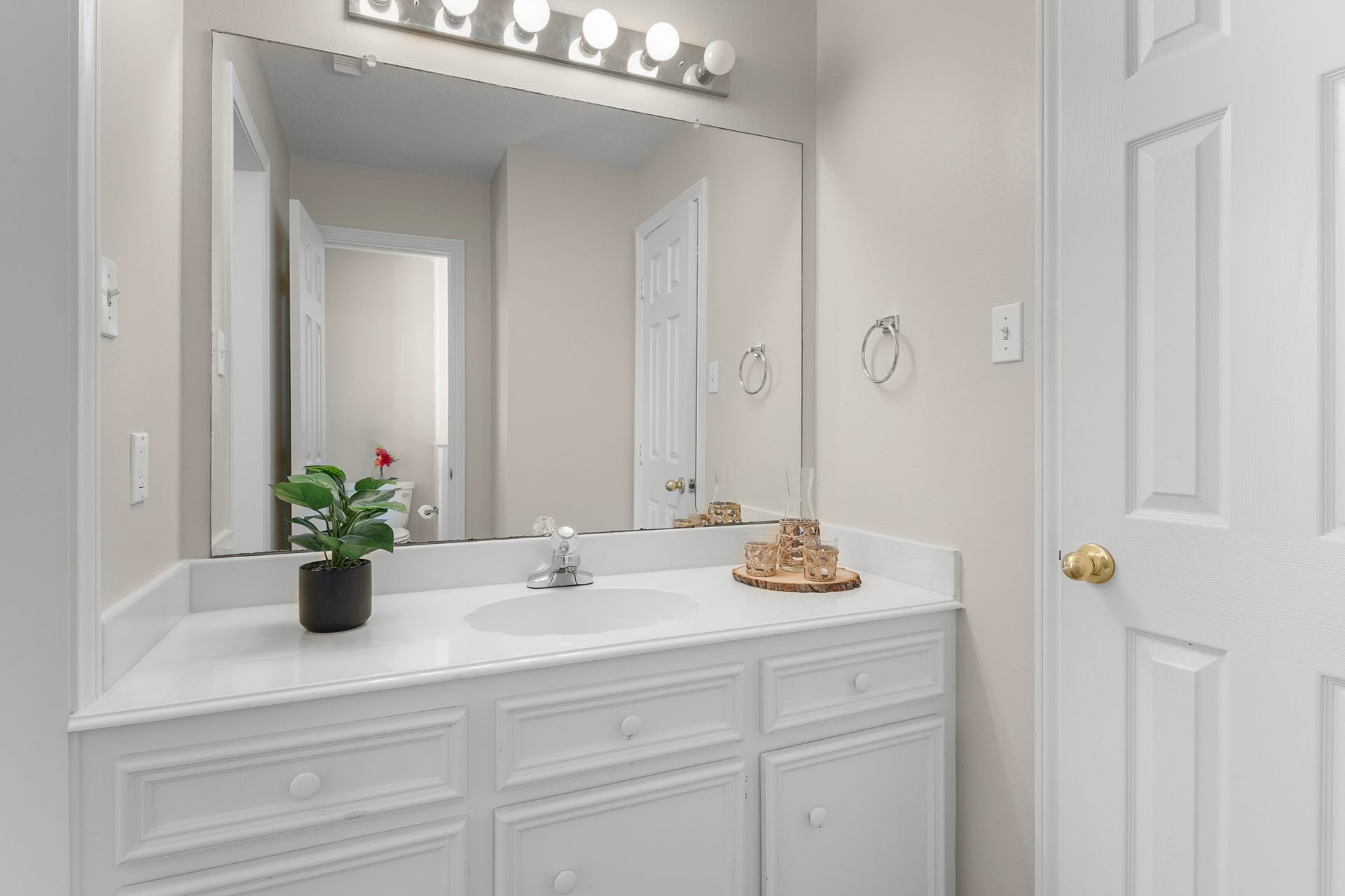 16314 Graven Hill Drive, Spring, TX 77379 Classic white cabinetry, a broad mirror and bright vanity lighting keep the bathroom feeling fresh and functional.