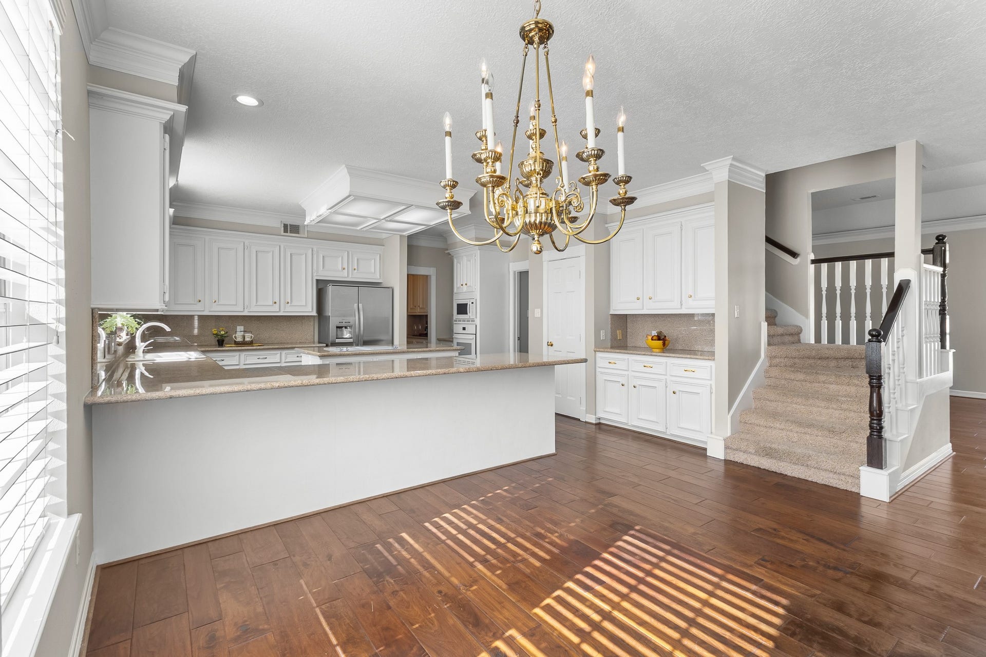 16314 Graven Hill Drive, Spring, TX 77379 The kitchen transitions naturally into the breakfast area, with a chandelier and warm wood flooring creating a welcoming everyday dining space.