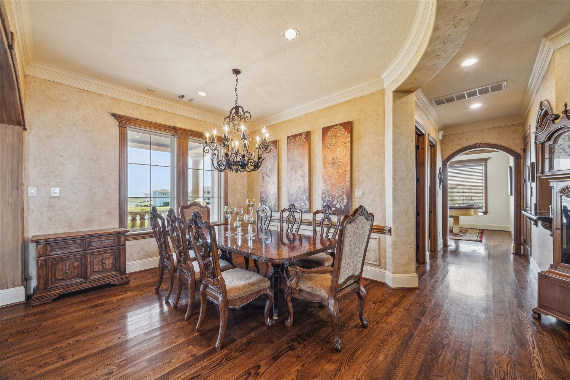9 Happy Jack, Hitchcock, TX 77563 The elegant formal dining room features rich hardwood flooring, a tray ceiling with crown molding, and abundant natural light. Arched entryways enhance the rooms timeless architecture