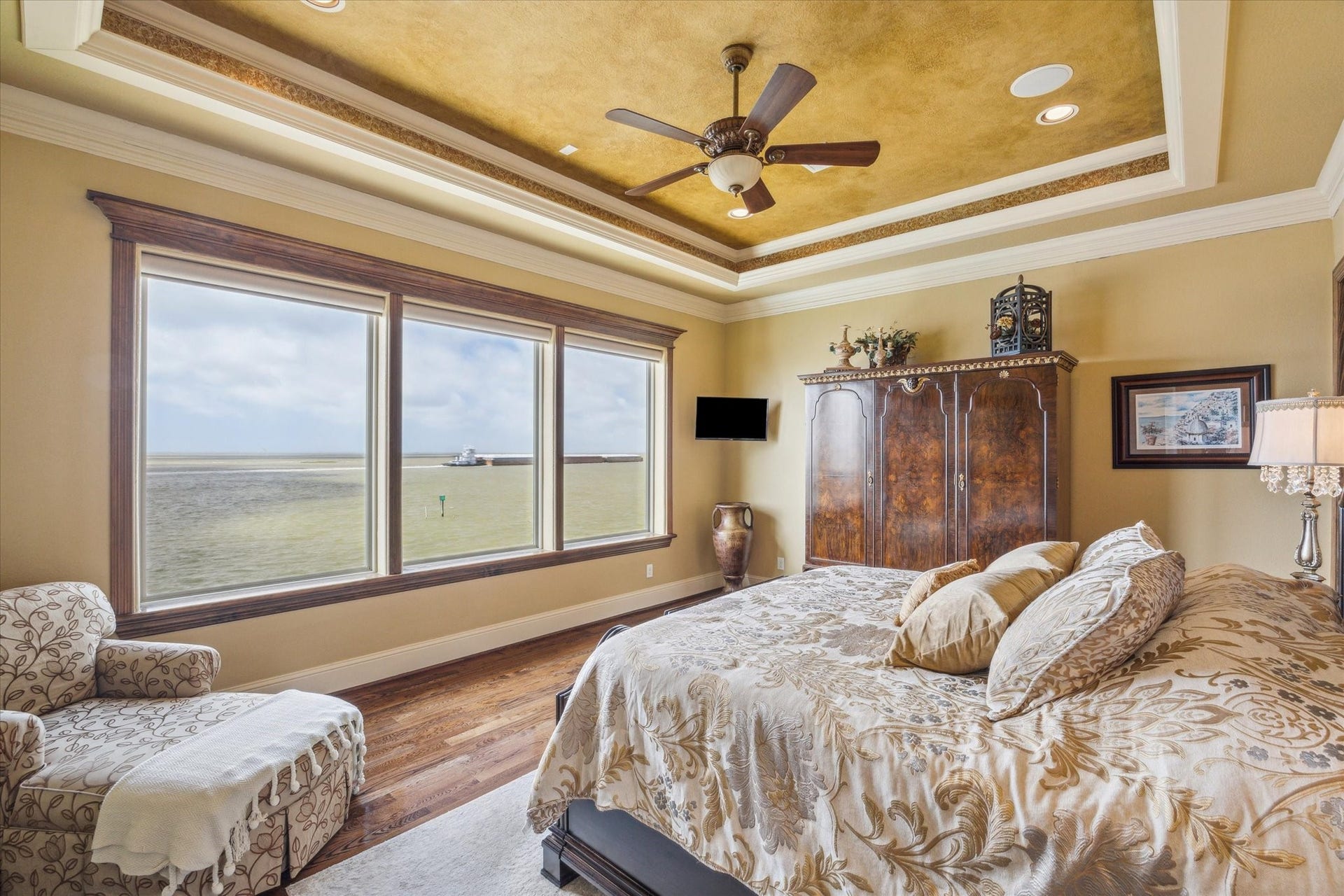 9 Happy Jack, Hitchcock, TX 77563 The primary suite features expansive windows with remote-control blinds, framing truly inspirational views of West Galveston Bay. A recessed ceiling adds a touch of architectural elegance, enhancing the rooms serene and sophisticated ambiance