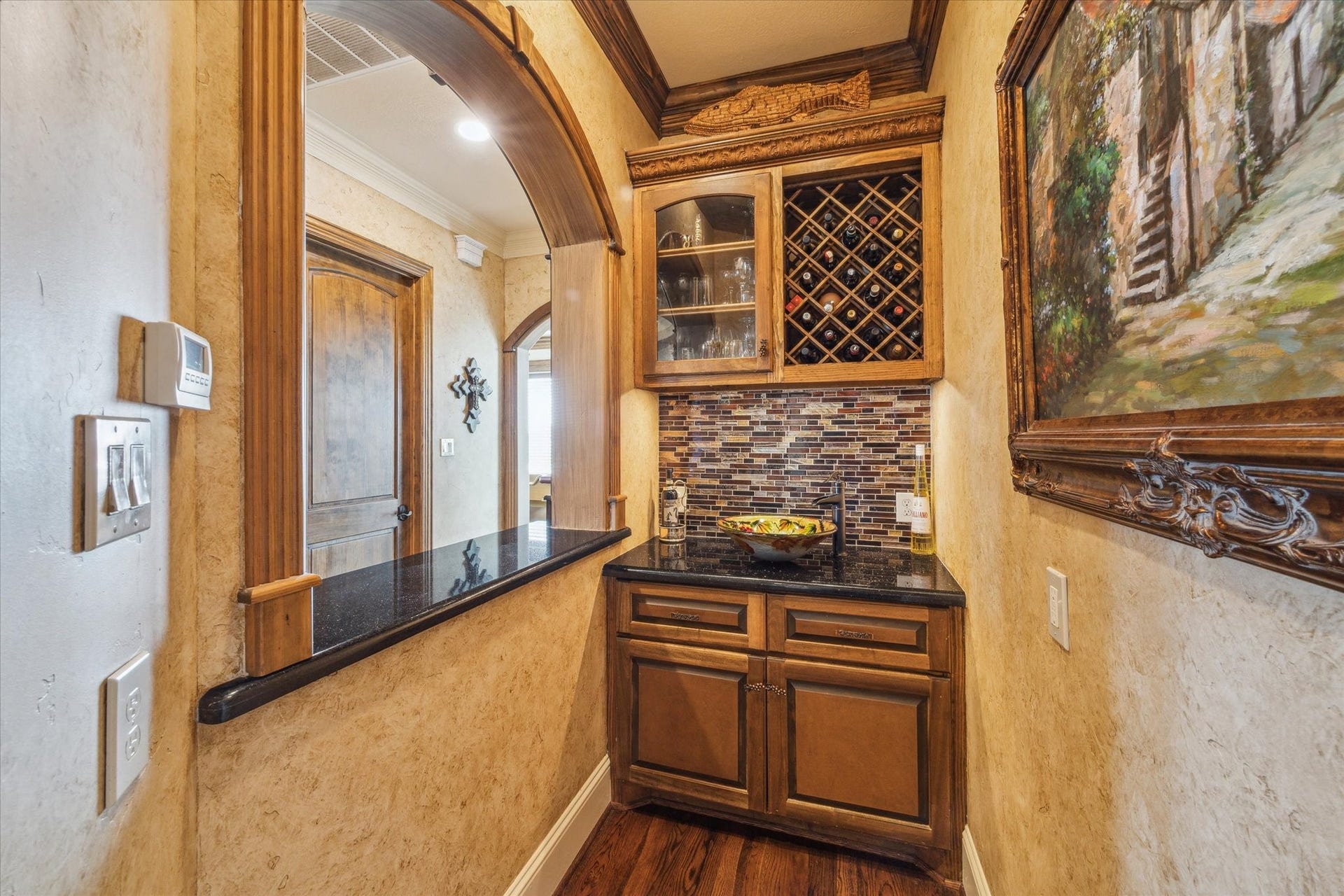 9 Happy Jack, Hitchcock, TX 77563 This bold and unique wet bar features custom wood cabinetry, a built-in wine rack, striking granite countertops, and a tile backsplash. An arched pass-through enhances the connection to the surrounding living spaceperfect for entertaining
