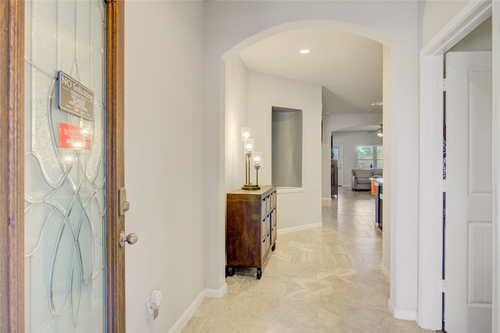 Step inside to a bright, welcoming foyer featuring elegant tile flooring, arched architectural details, and an inviting open layout.