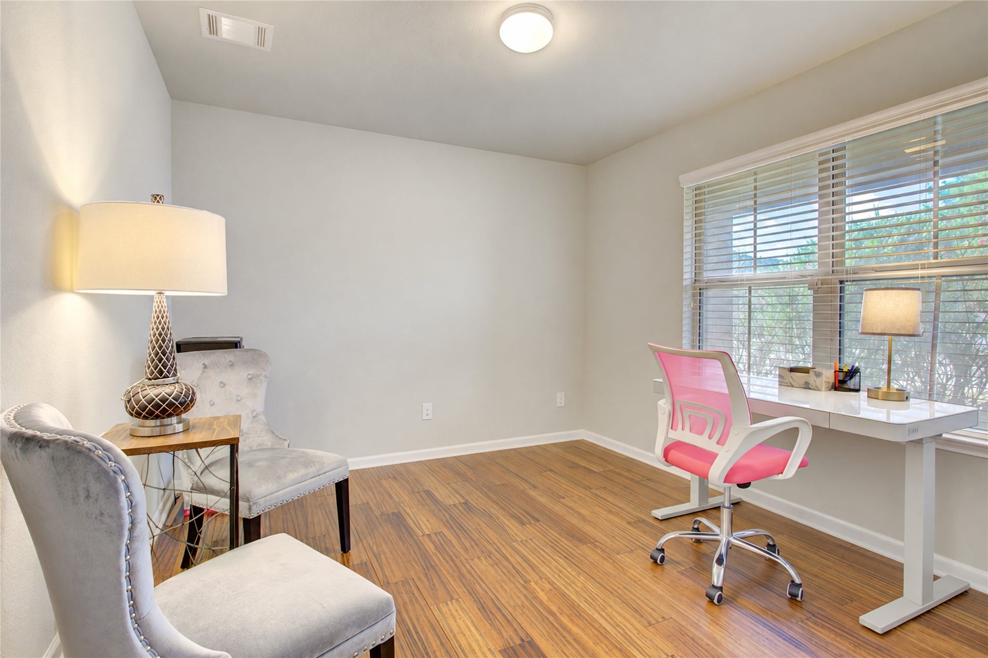Just off the entry, Work from home in comfort! This versatile room features beautiful wood flooring and abundant natural light perfect for an office or additional bedroom.
