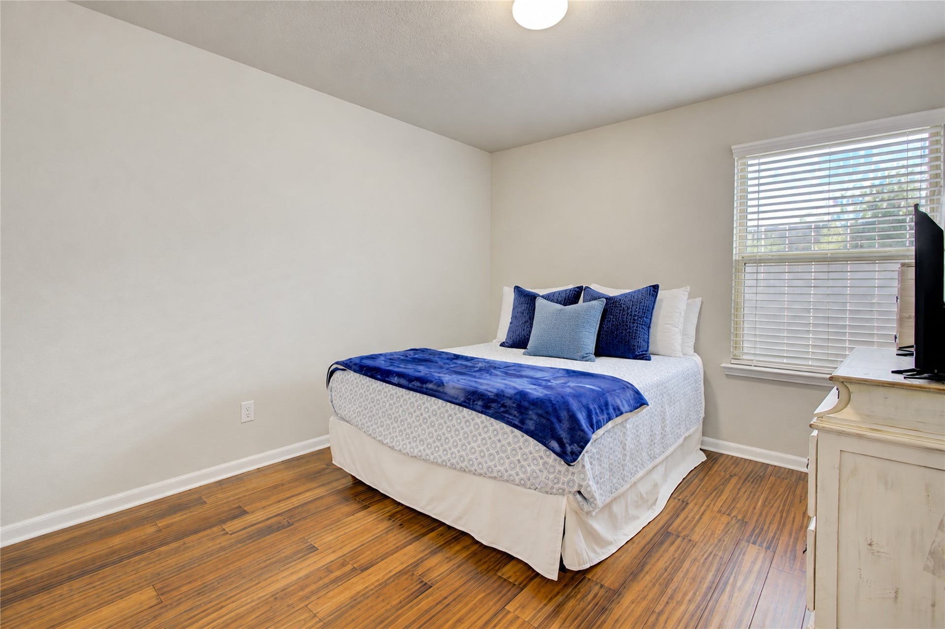 Another versatile bedroom offering wood flooring, natural light, and flexibility to create a comfortable space of your own.