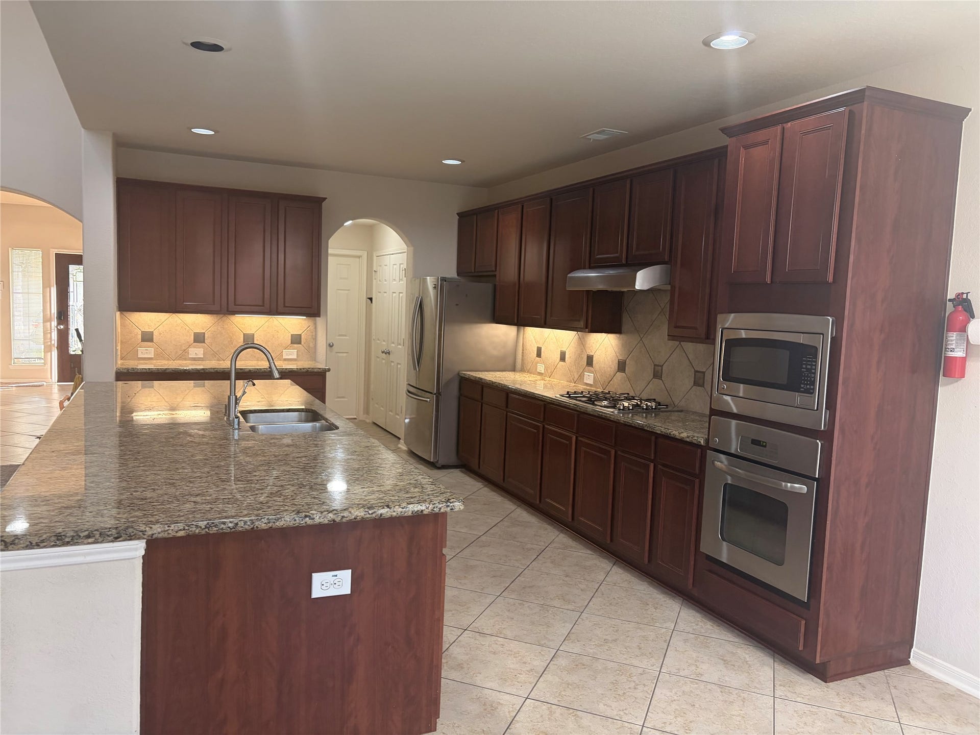 1230 Martinez Court, Friendswood, TX 77546 Large island with breakfast bar ideal for family, gatherings, and entertainment. Stainless steel appliances.
