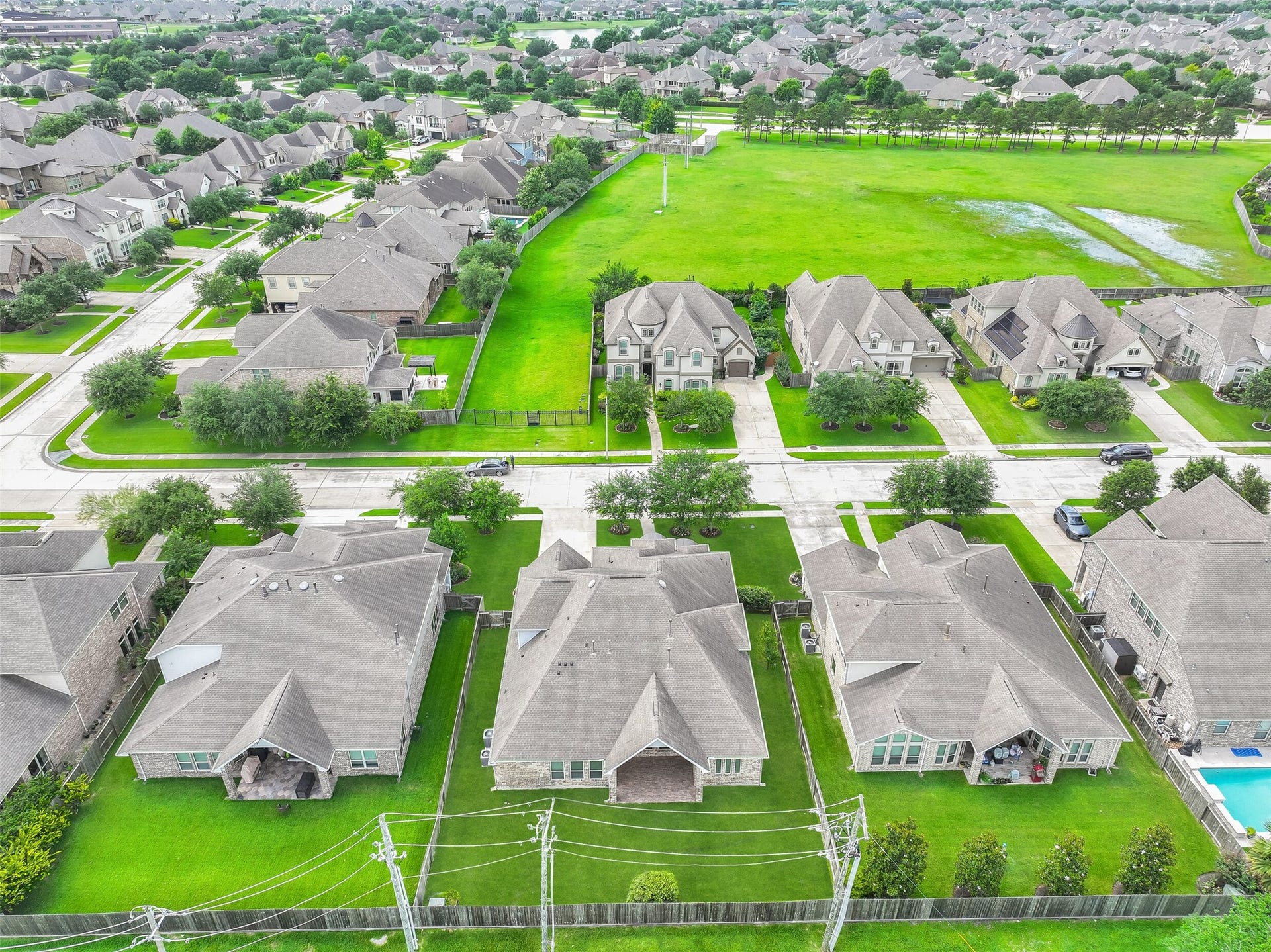 1321 Summer Field Lane, Friendswood, TX 77546 An aerial perspective highlights the home's generous lot size and desirable position within West Ranch. The backyard offers exceptional outdoor space compared to many newer homes, while the surrounding neighborhood showcases the community's attractive streetscapes, mature landscaping, and well-maintained homes.