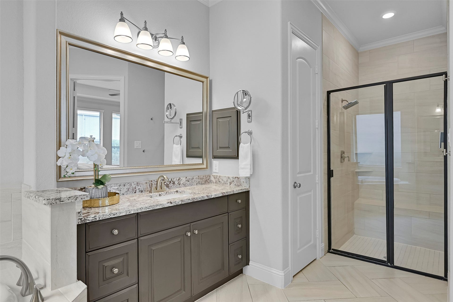1321 Summer Field Lane, Friendswood, TX 77546 Another view highlights the oversized walk-in shower with tile surround, bench seating, and frameless-style glass enclosure. Separate vanities provide excellent storage and countertop space, while neutral finishes create a timeless and elegant design.