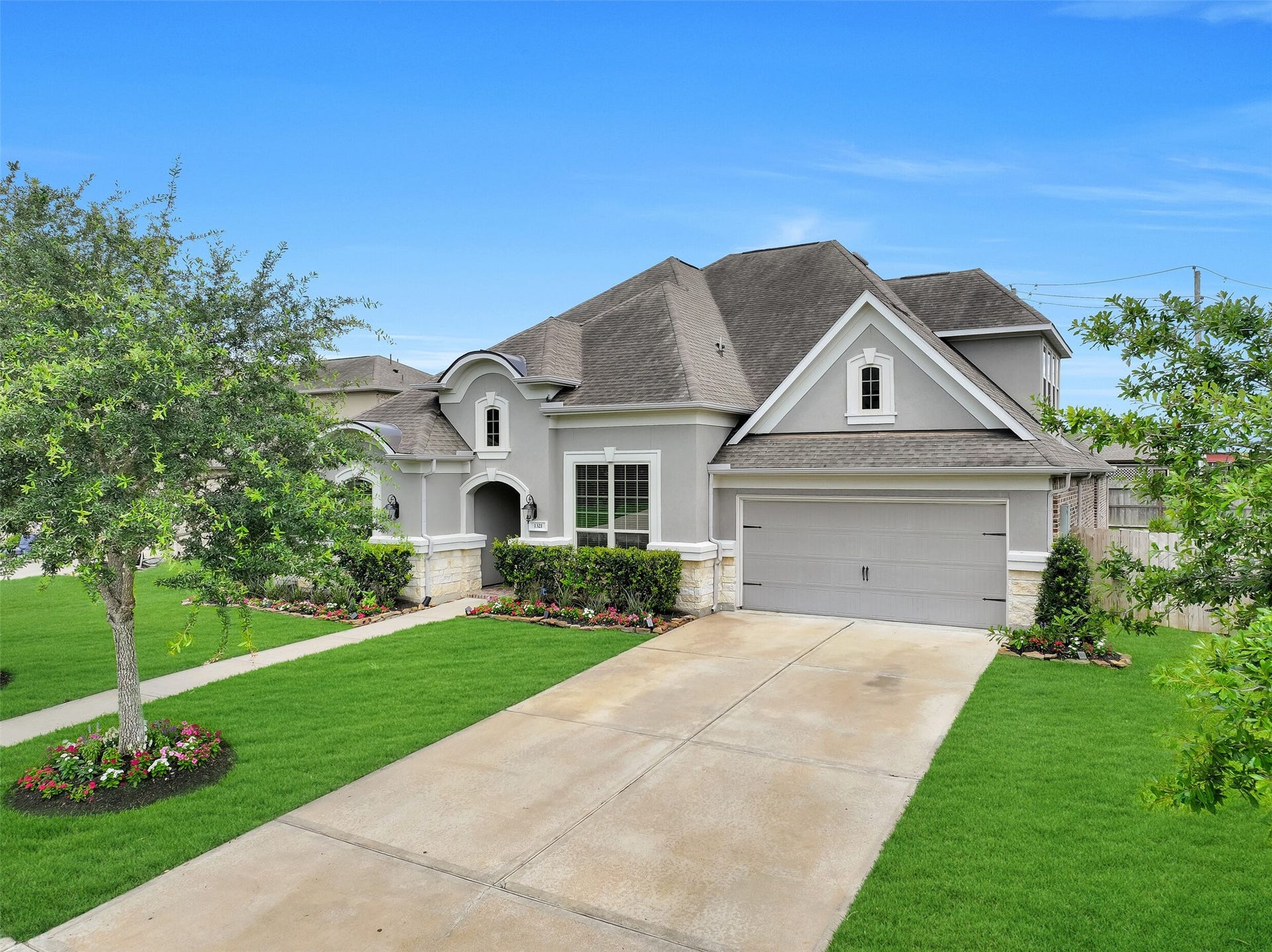 1321 Summer Field Lane, Friendswood, TX 77546 From this angle, the home's impressive curb appeal comes into full view with its stucco and stone exterior, mature oak trees, fresh landscaping, solar-powered landscape lighting, and double-wide driveway leading to the tandem 3-car garage. Located within the gated Arbor Gate section of West Ranch and zoned to Friendswood ISD.