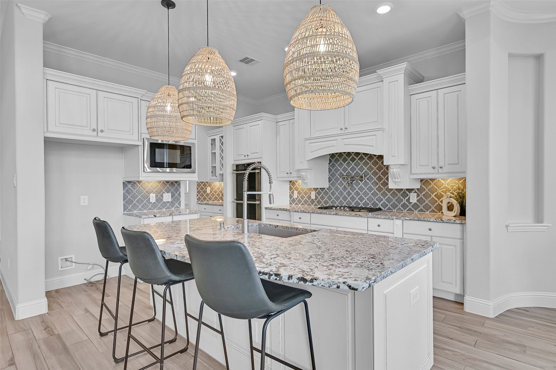 1321 Summer Field Lane, Friendswood, TX 77546 The island kitchen combines beauty and function with granite countertops, abundant cabinetry, undercabinet lighting, decorative crown molding, and stylish pendant lighting. A large curved island provides seating, prep space, and a central gathering point for family and guests.