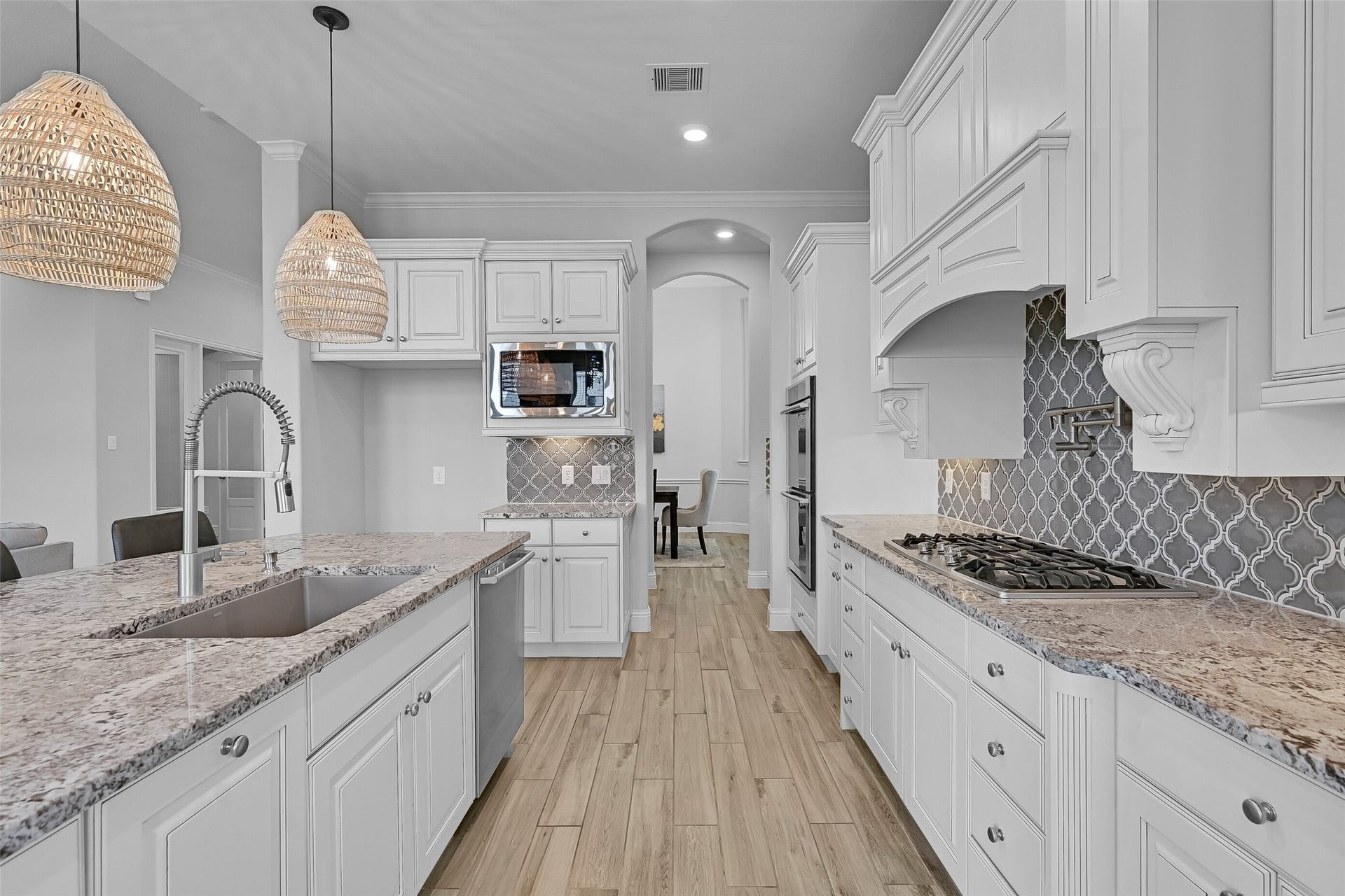 1321 Summer Field Lane, Friendswood, TX 77546 Designed with the home chef in mind, this kitchen offers extensive counter space, a 5-burner Electrolux gas cooktop with pot filler, undercabinet lighting, and abundant storage. The thoughtful layout keeps everything within easy reach while maintaining an open connection to the living areas.