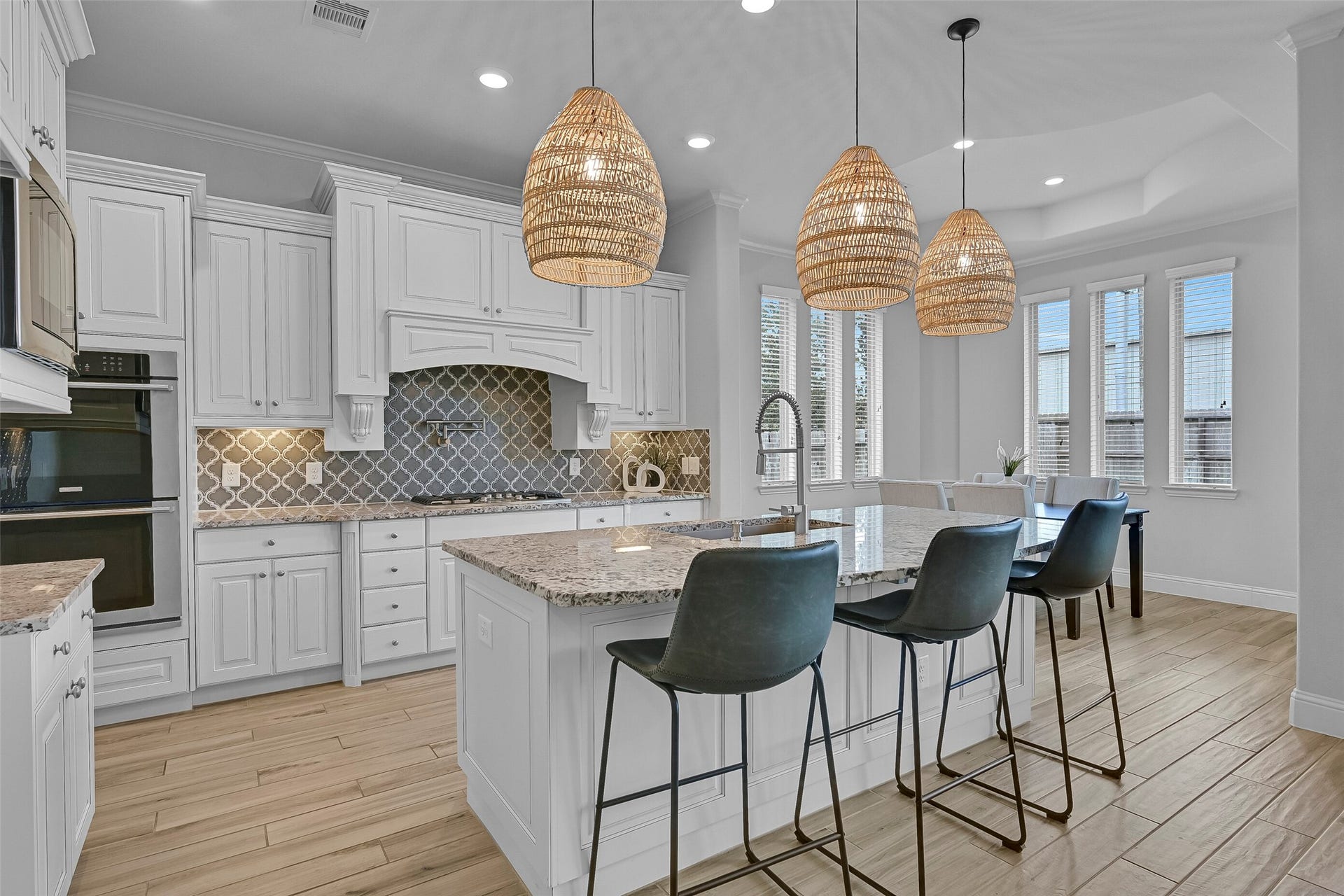 1321 Summer Field Lane, Friendswood, TX 77546 Designed for both everyday convenience and hosting guests, the island kitchen features granite countertops, an arabesque tile backsplash, undercabinet lighting, a 5-burner Electrolux gas cooktop with pot filler, dual Electrolux convection ovens, and a huge single-basin composite sink overlooking the breakfast room.