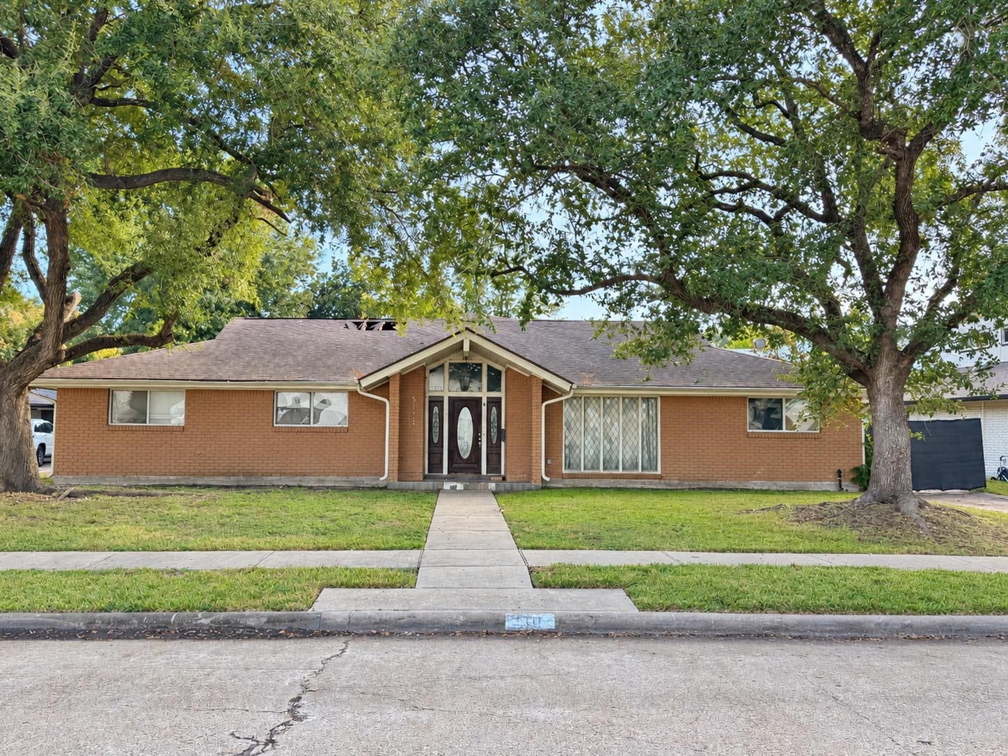 5111 Glenmeadow Drive, Houston, TX 77096 Subject property fire damaged house with large oak trees