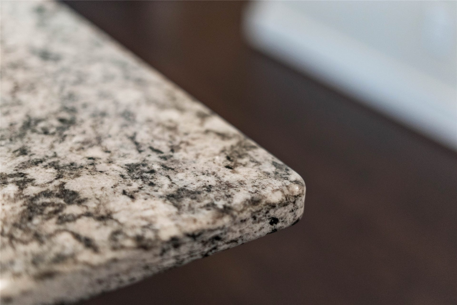A closer view highlighting the premium quality of the granite countertops, showcasing the intricate natural patterning, polished finish, and durable eased edge profile.