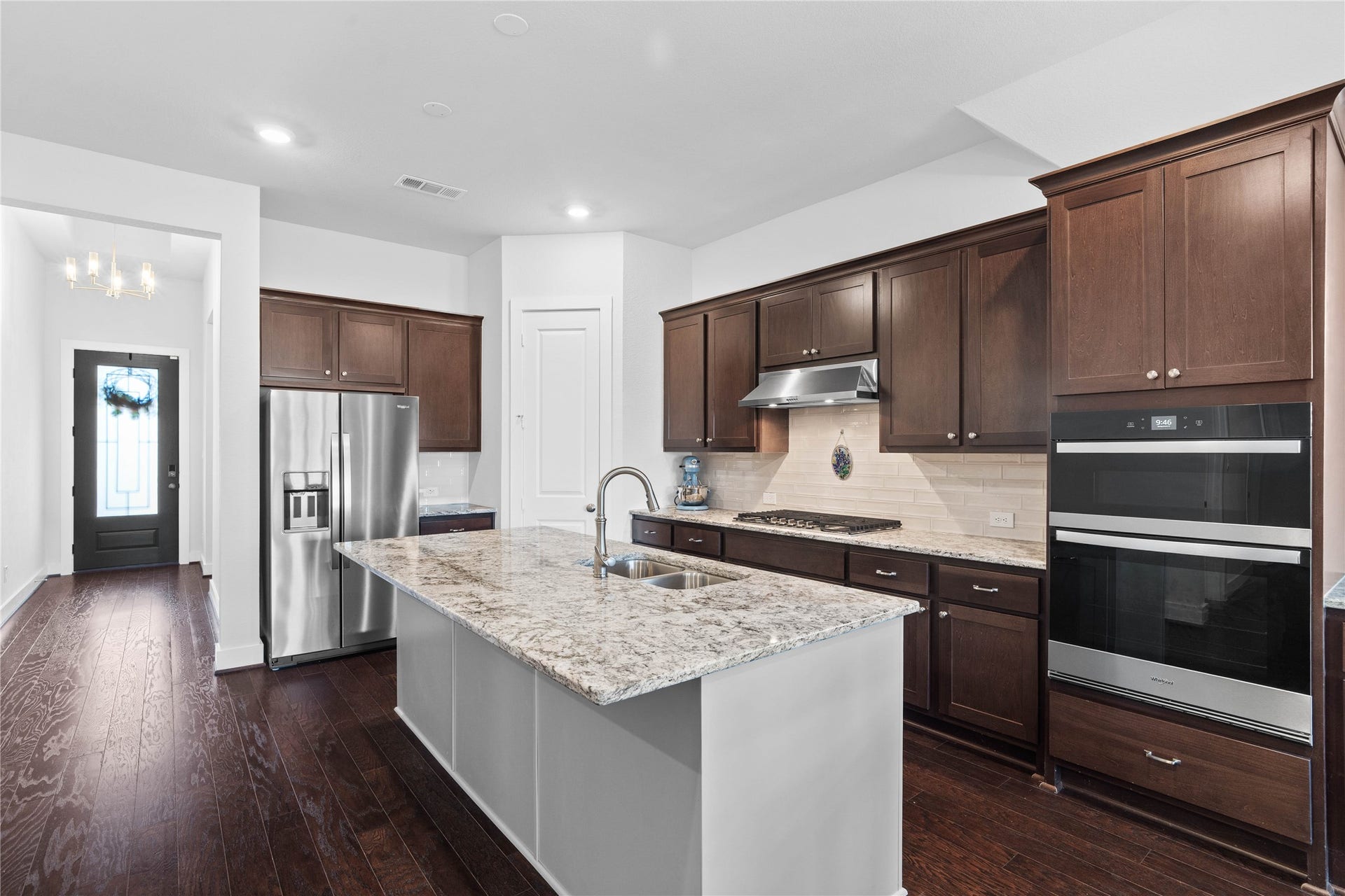 Perfect for welcoming guests as they enter the home, the wide entryway flows effortlessly into the stunning kitchen that serves as an immediate showcase of the home's high-end finishes and spacious layout.