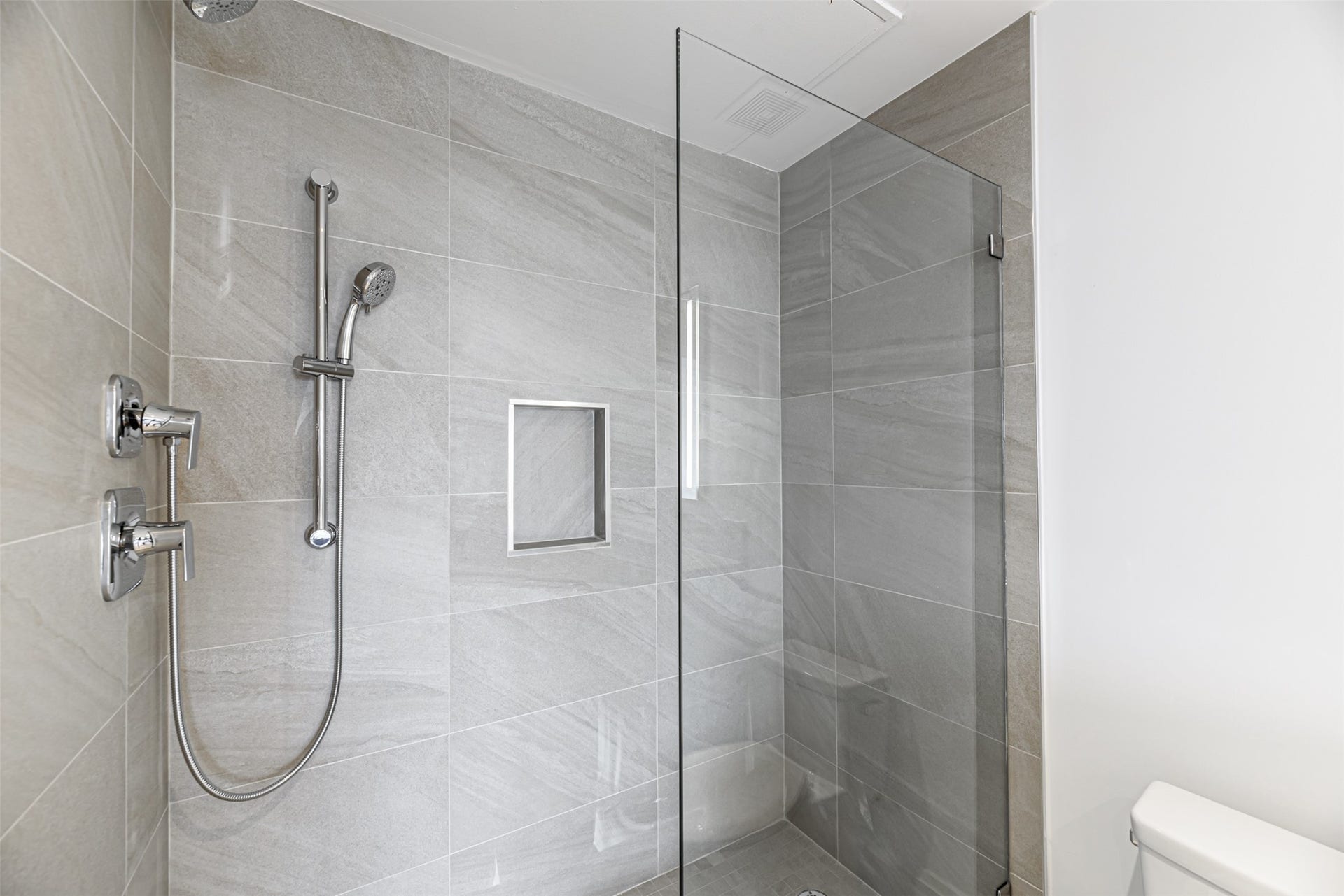 1701 Hermann Drive, #25A, Houston, TX 77004 Oversized shower features stacked porcelain tile, soap niche and Euroglass door.