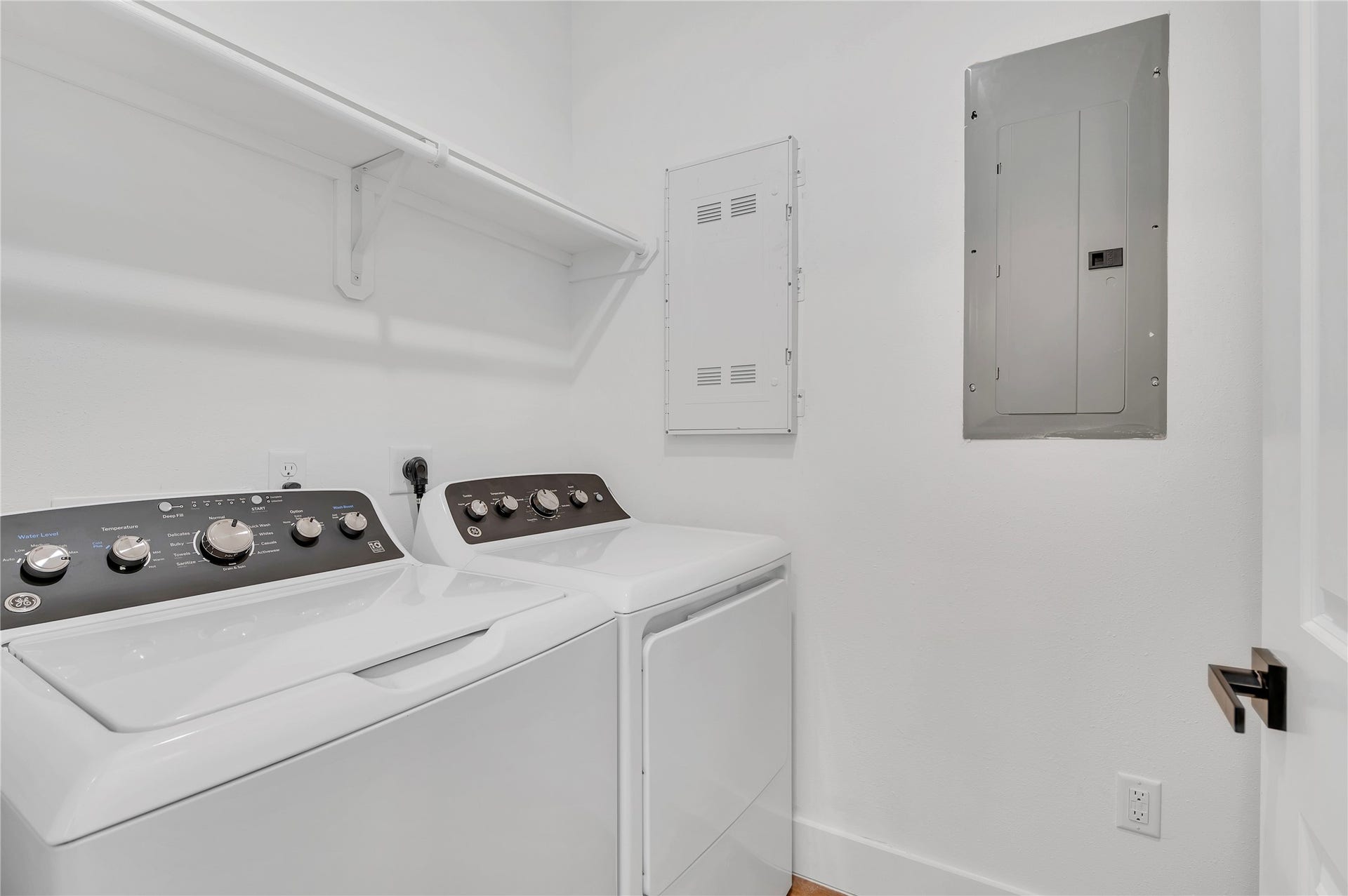 119 Kirby Road, #5304, Taylor Lake Village, TX 77586 Modern laundry room equipped with a washer, dryer, and convenient overhead shelving for storage.