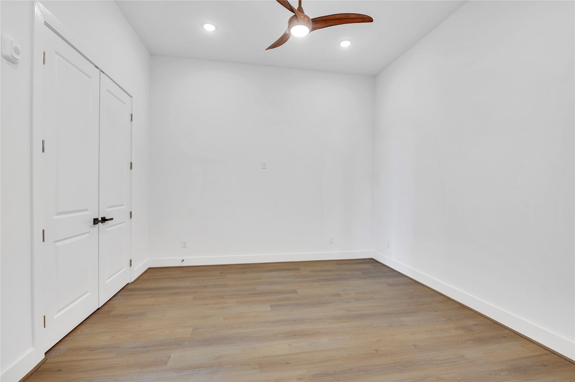 119 Kirby Road, #5304, Taylor Lake Village, TX 77586 Spacious room with elegant wood flooring, recessed lighting, and a stylish ceiling fan, complemented by double doors for added convenience.