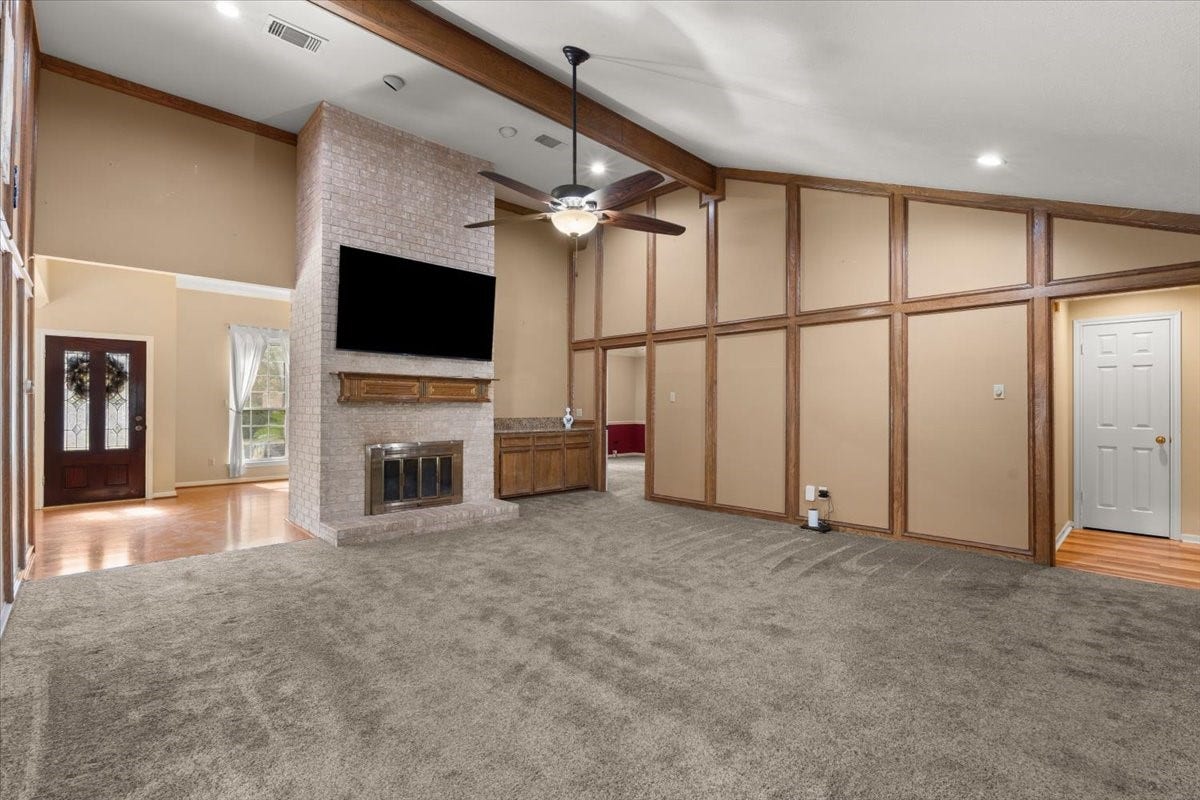 Enjoy a large, inviting living area featuring a cozy fireplace and an open connection to the front entryway, creating a warm welcome and an ideal space for relaxing or entertaining.