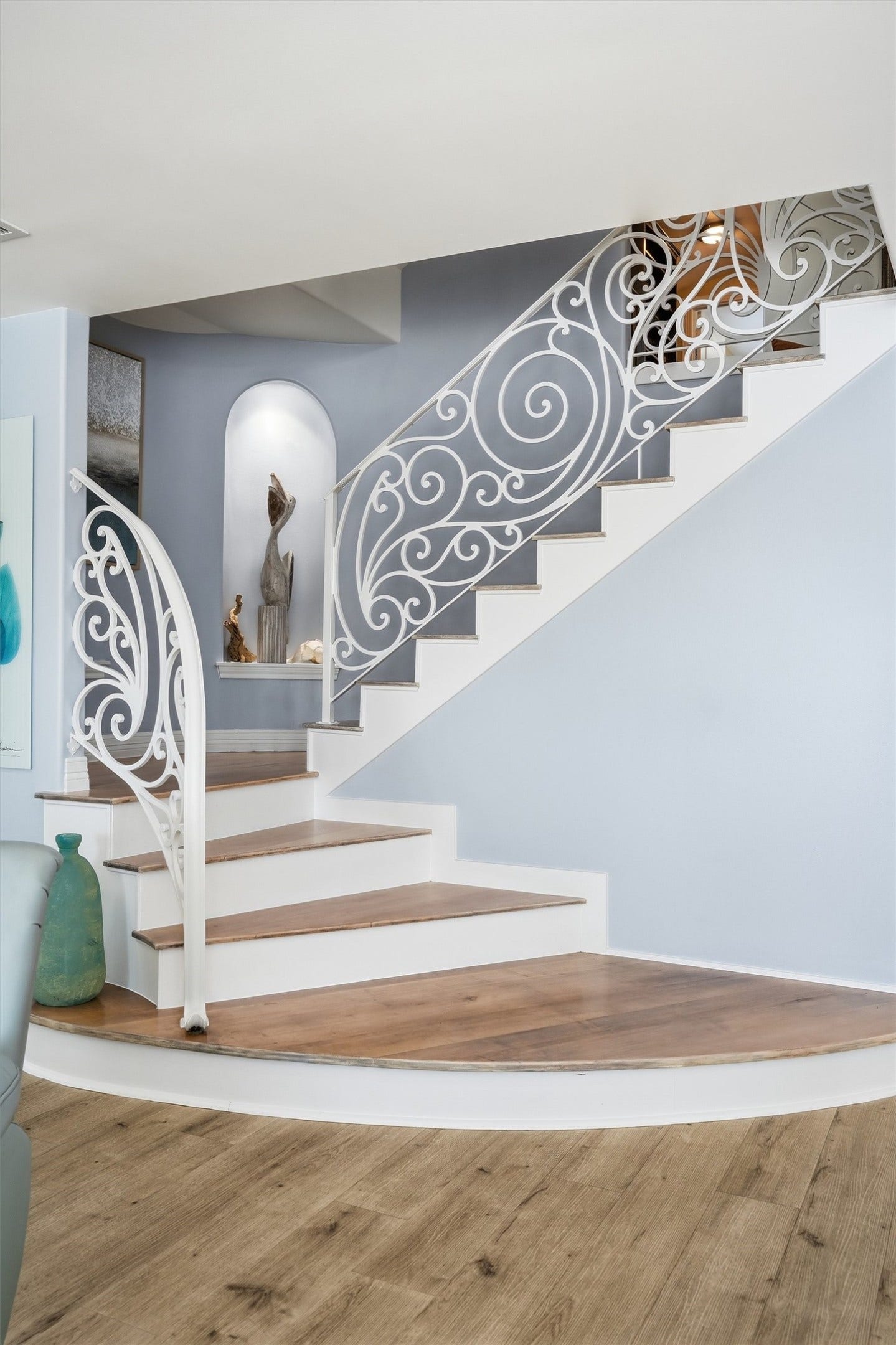 A distinctive curved staircase with decorative ironwork adds character and architectural interest to the homes interior.