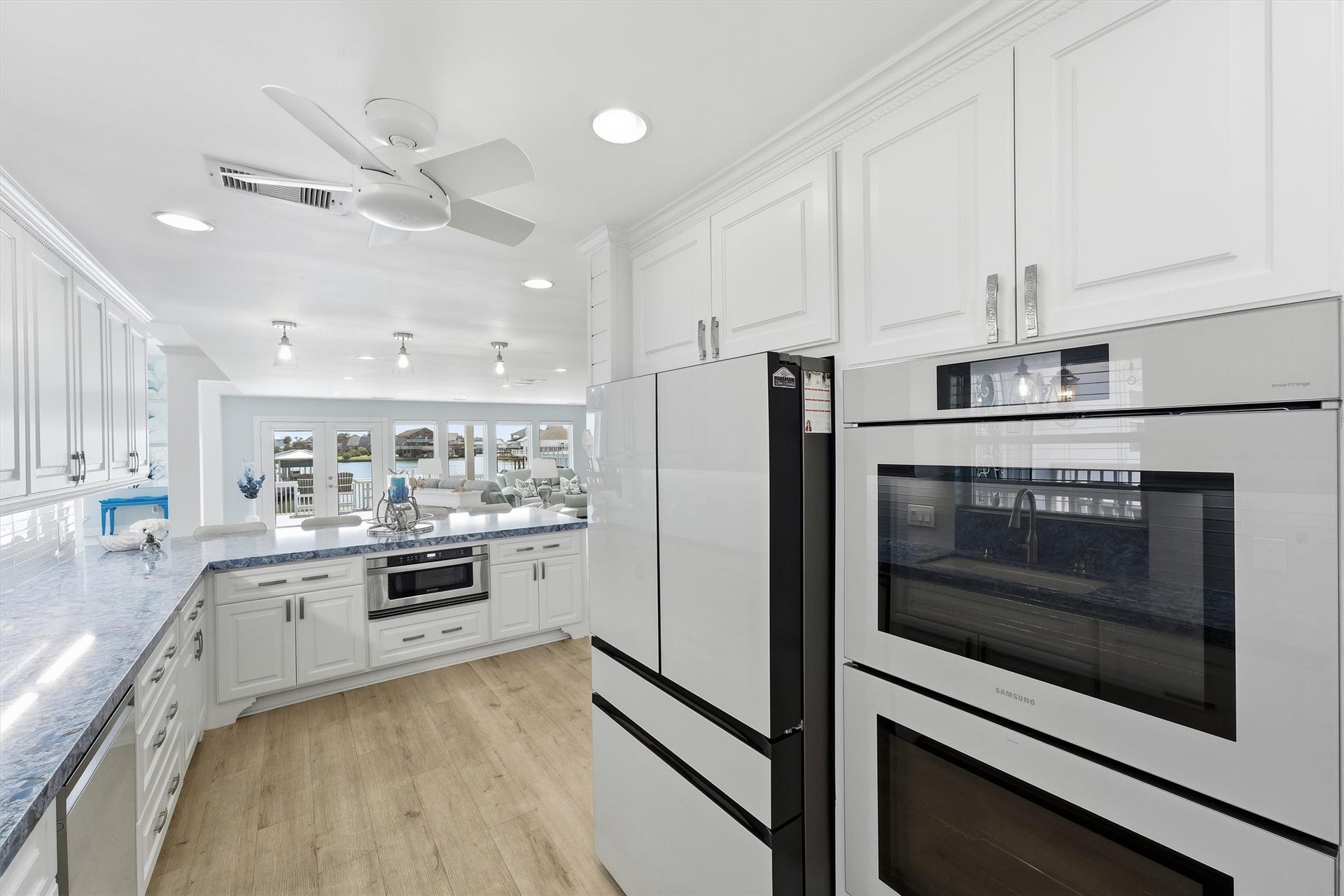 Well-appointed kitchen with Samsung Bespoke appliances, double ovens, extensive cabinetry, and an open connection to the waterfront living areas.