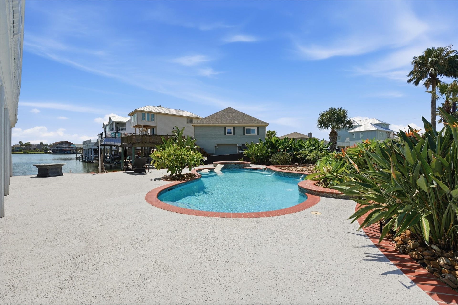 A private pool and spa surrounded by tropical landscaping create a resort-like setting just steps from the water.