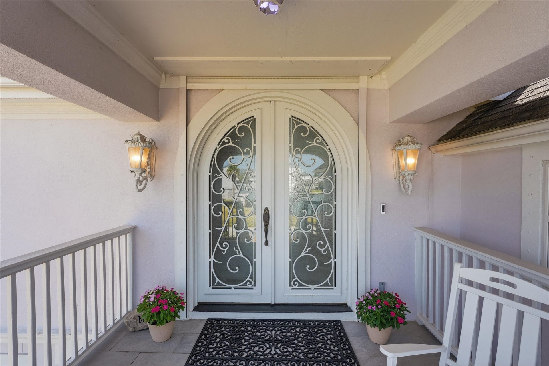 The covered front porch offers a welcoming entrance with architectural detailing and decorative double doors.