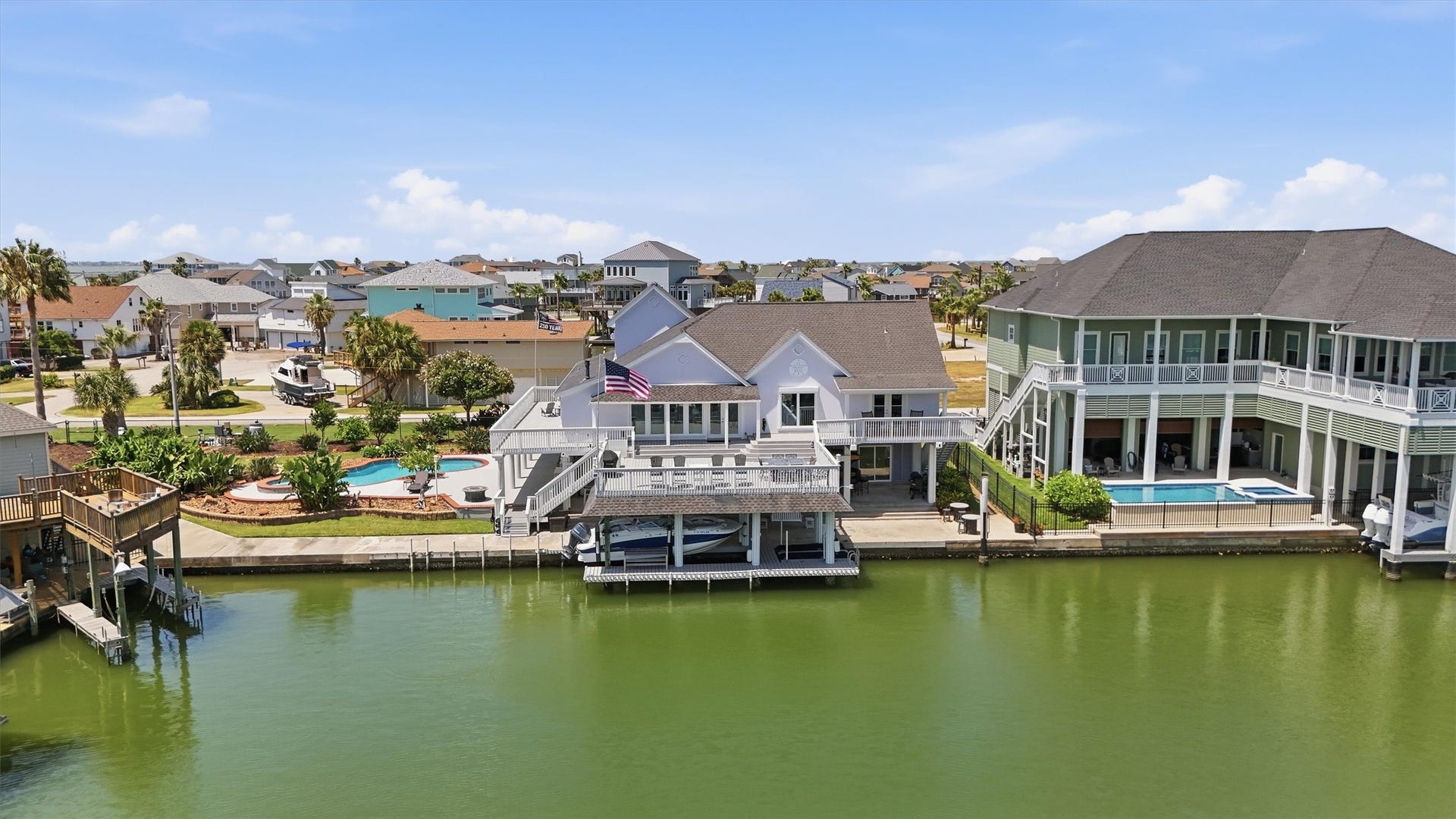 The Tiki Island lifestyle starts here with expansive waterfront decks, a private pool and spa, and a covered boat slip creating a seamless connection between home, water, and outdoor living.