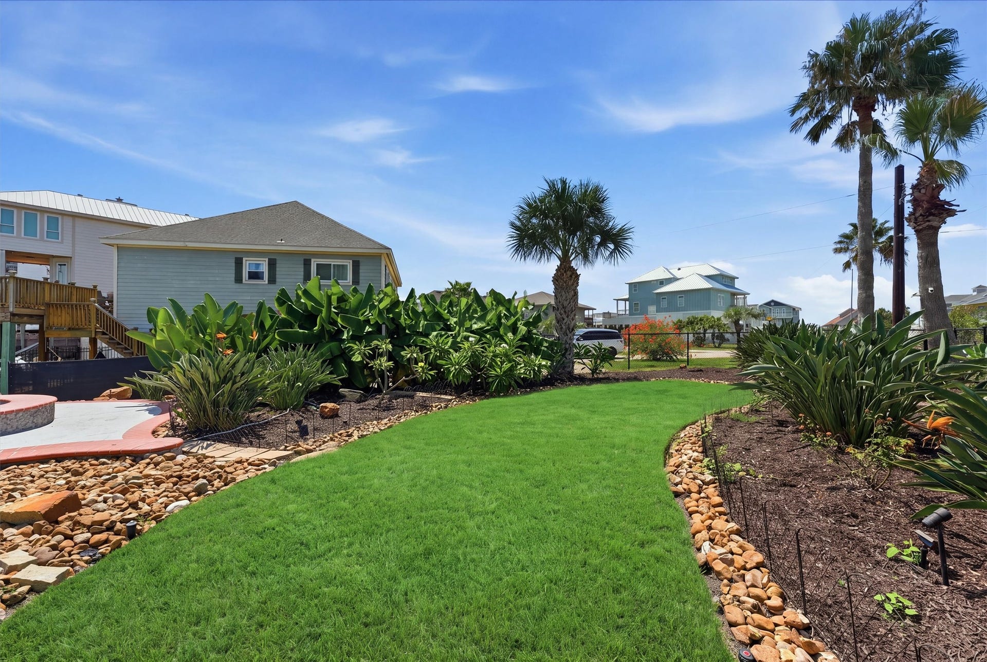 Expansive double-lot setting provides a rare amount of usable outdoor space with manicured lawn, tropical landscaping, and room to enjoy the coastal lifestyle.