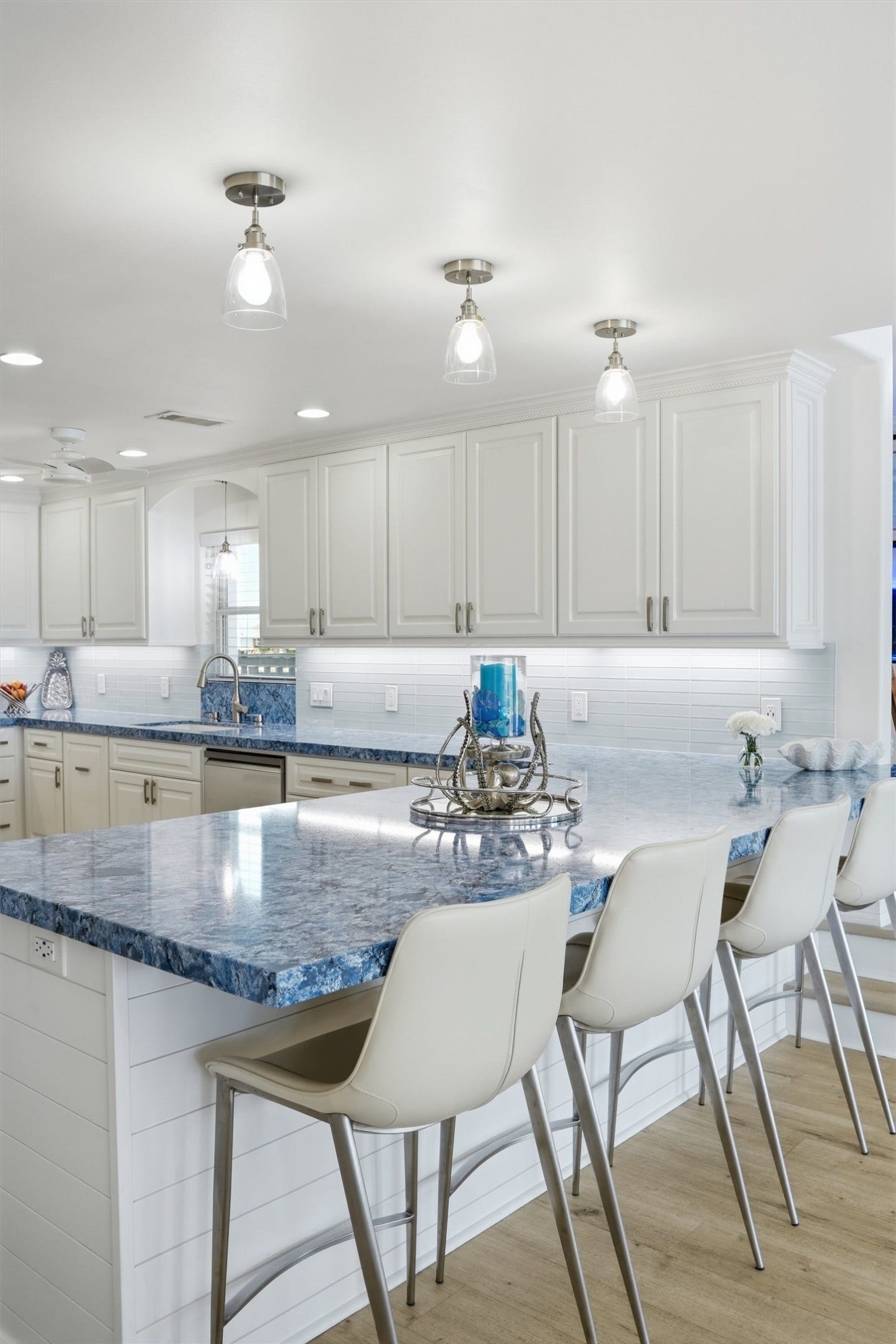Attention to detail shines in the kitchen, where striking blue quartz countertops create a beautiful statement and bring a custom feel to the oversized island.