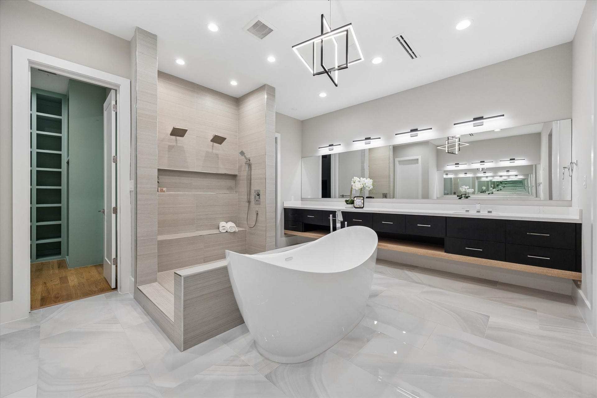 10943 Britoak Lane, Houston, TX 77079 Spa-inspired primary bath featuring a freestanding soaking tub, oversized walk-in shower, dual vanity, and contemporary finishes