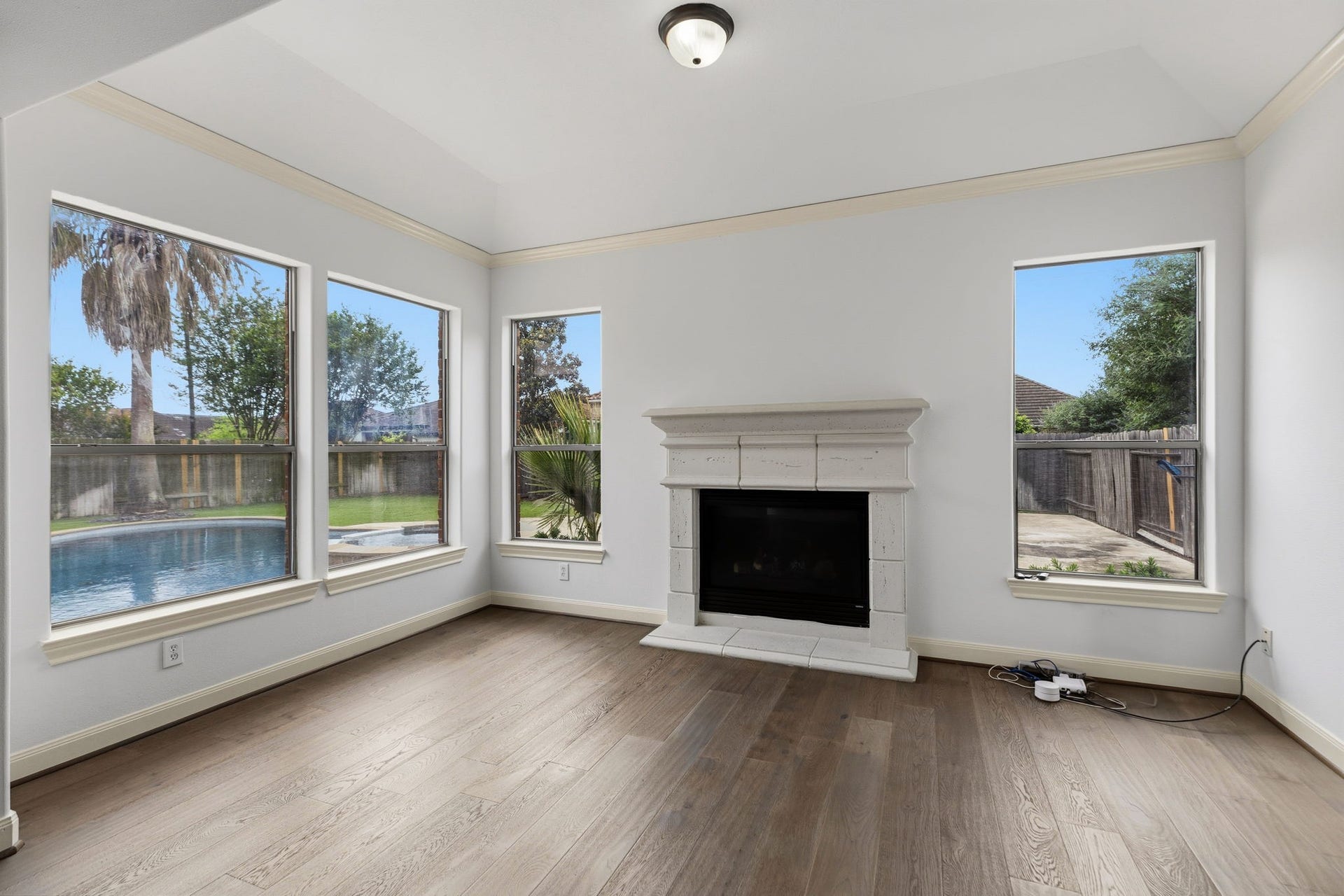 Primary retreat has extra sitting area with a fireplace and views into your beautiful yard!  Extra high vaulted ceiling.