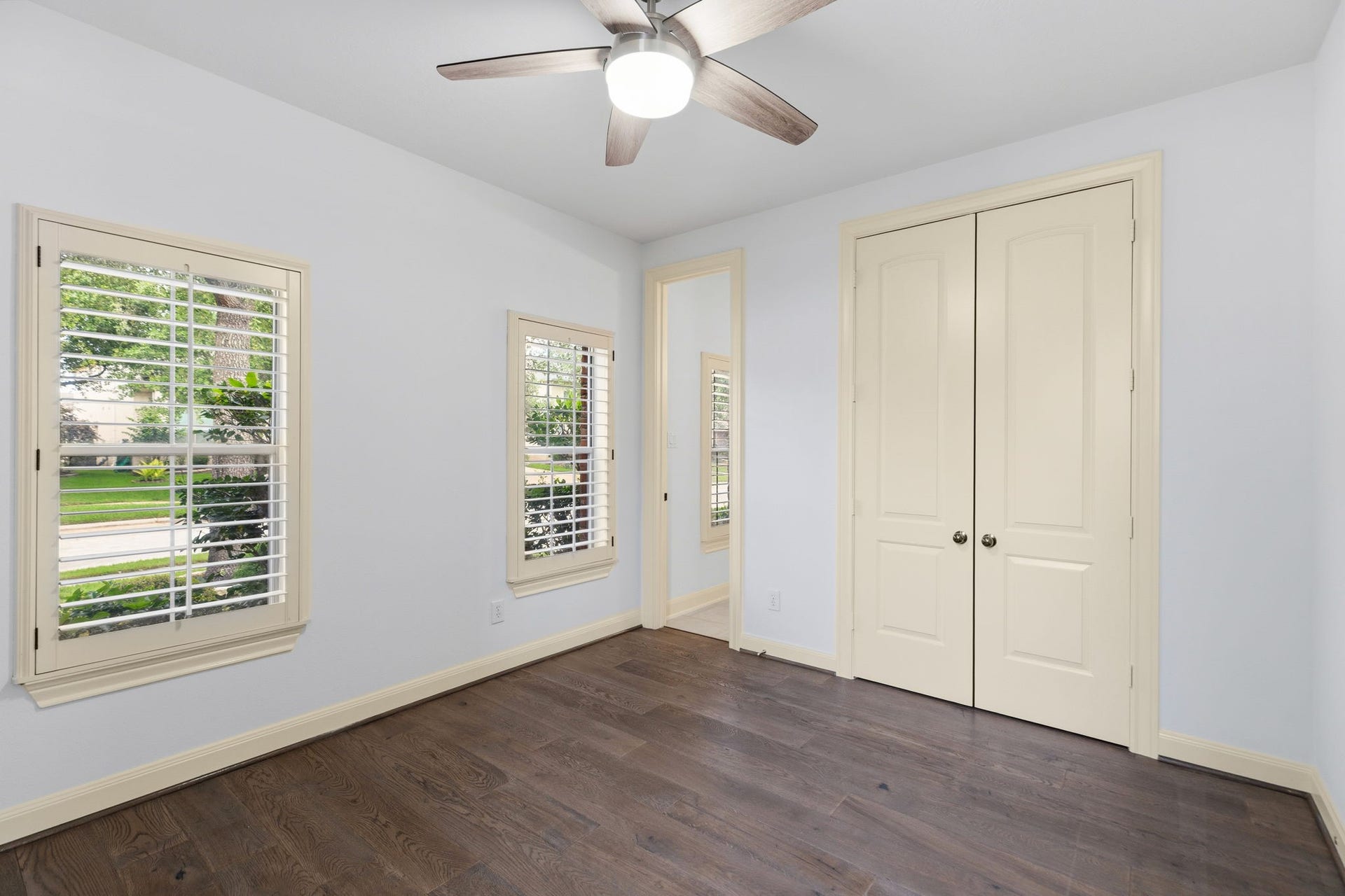 One of the secondary bedrooms with its own full bathroom downstairs.  Beautiful plantation shutters!