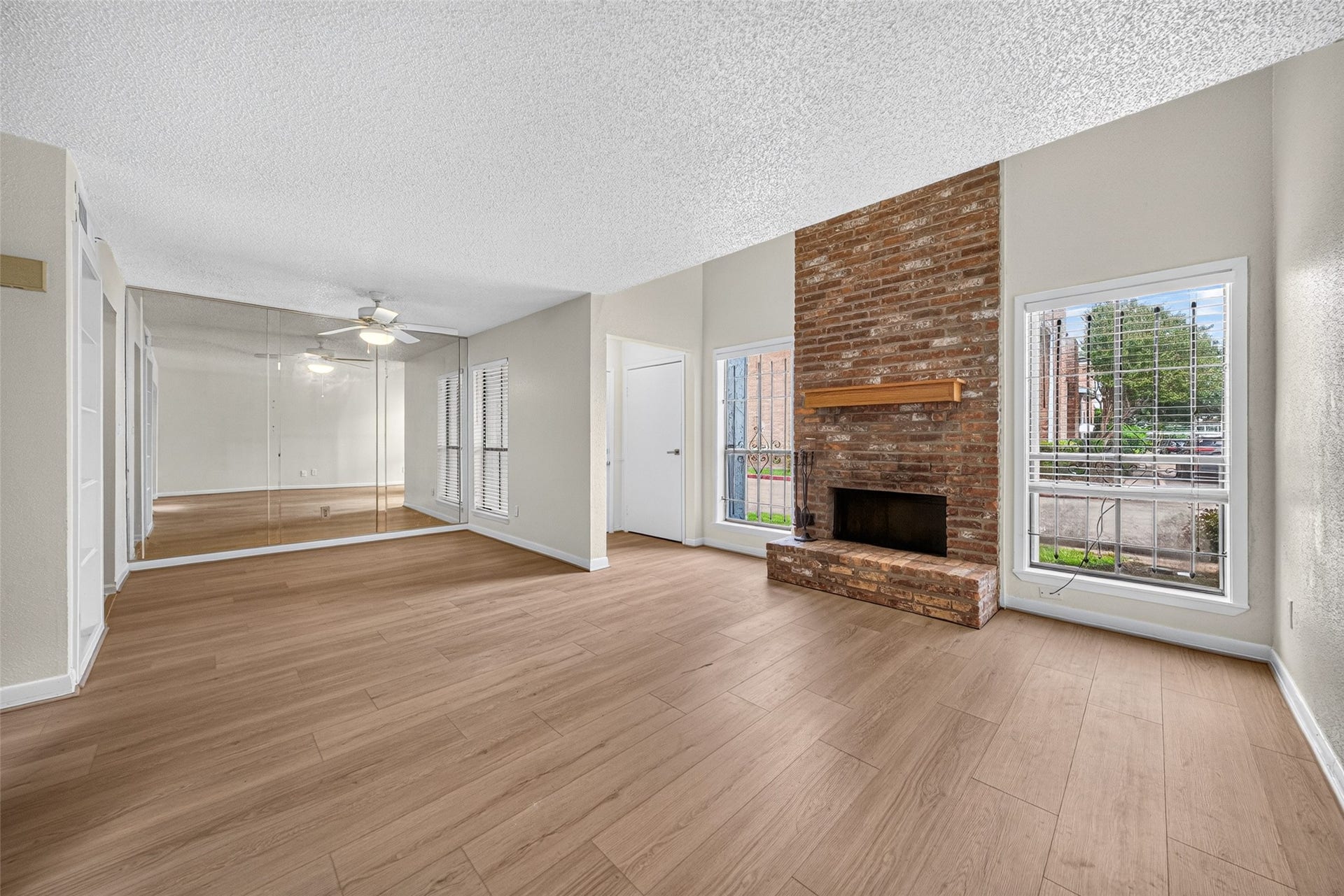 Spacious living room with brick fireplace and natural light