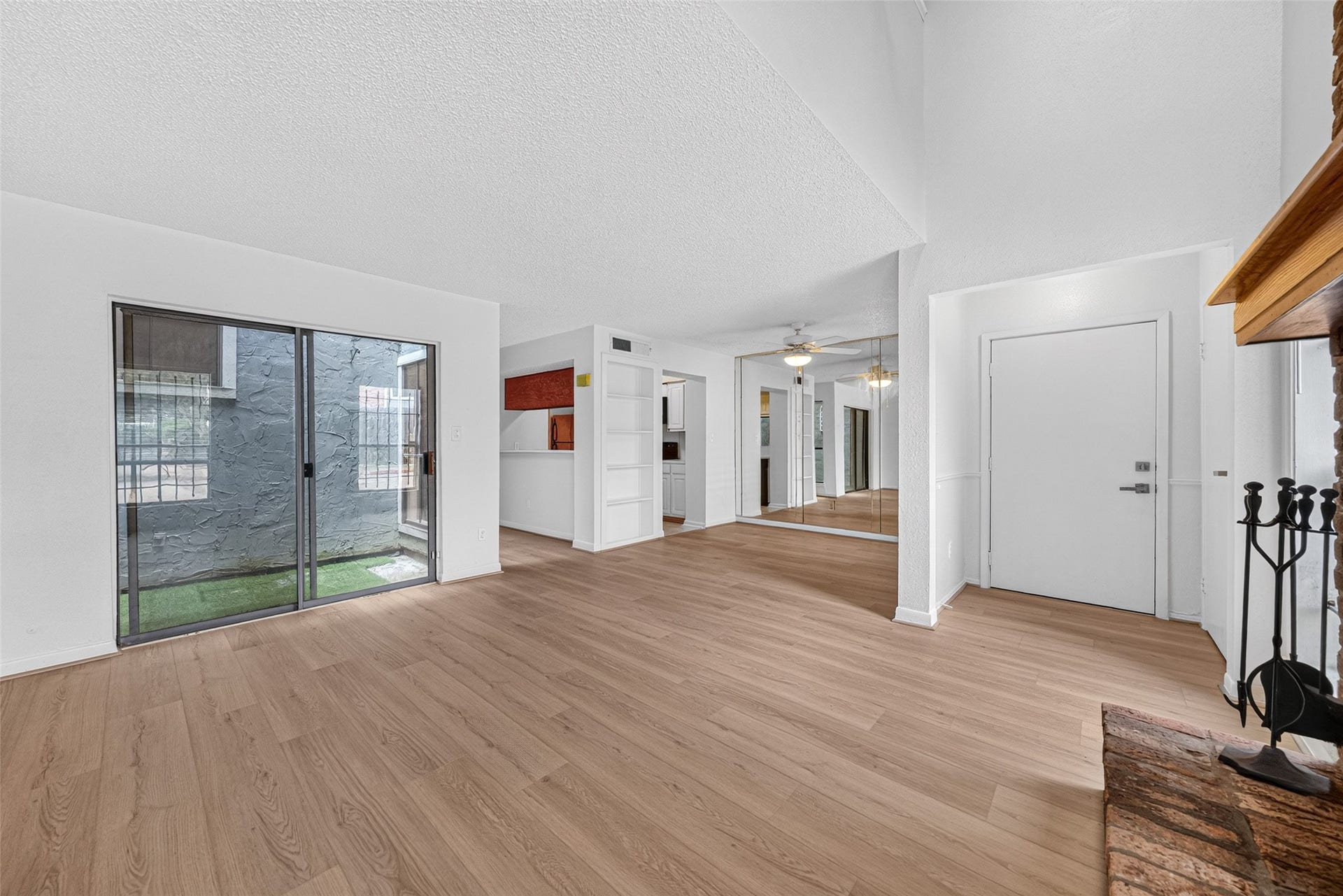 Open living area with wood-look flooring and courtyard access