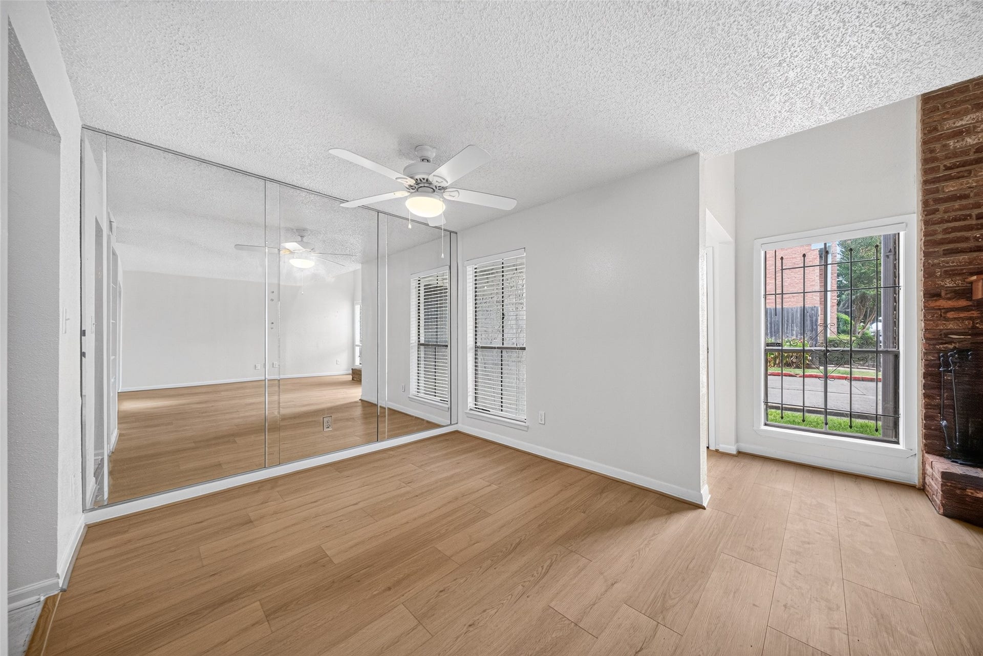 Dining area with attractive wood-look vinyl flooring, mirrored wall, and ceiling fan.