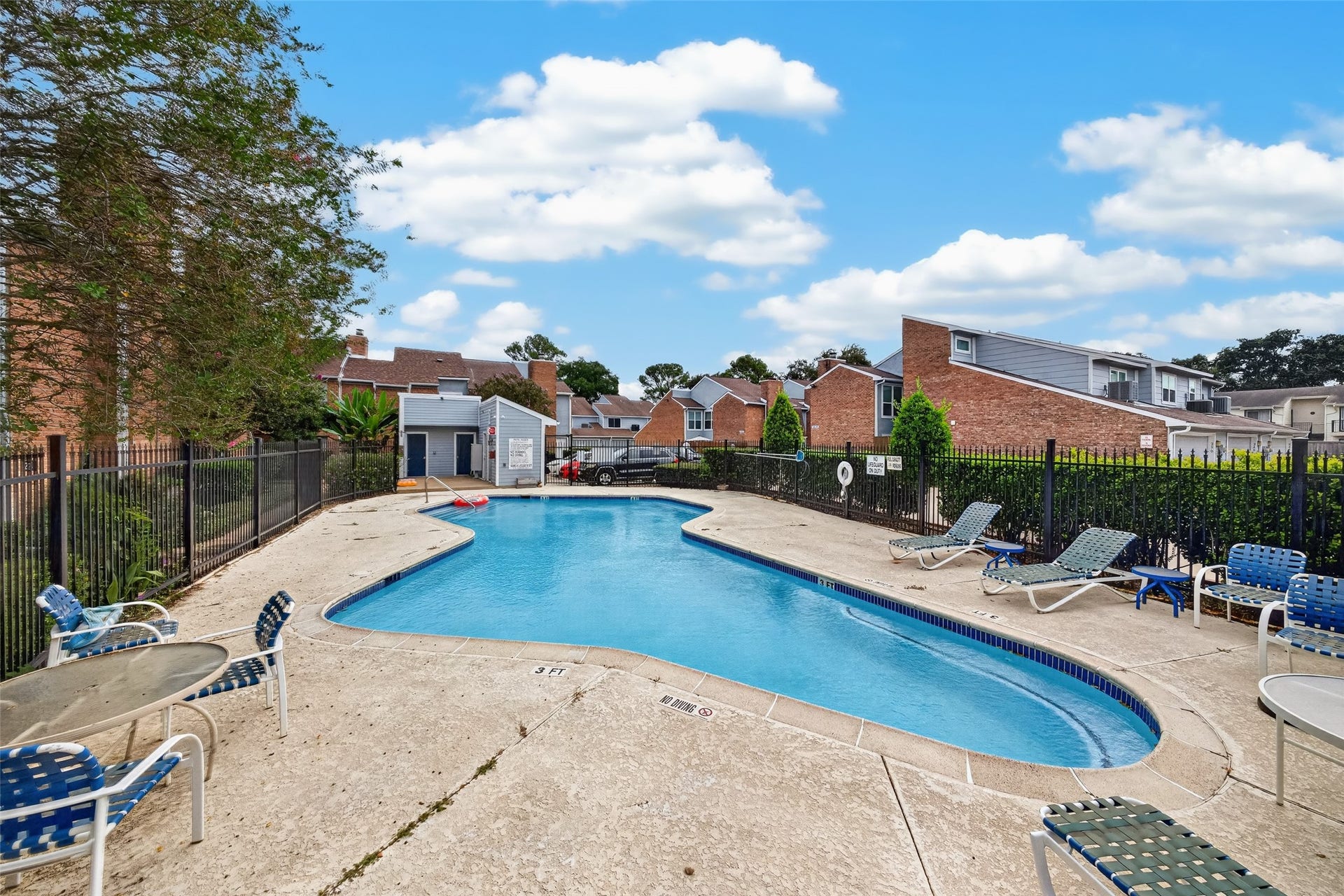 Enjoy the community swimming pool with surrounding lounge chairs and outdoor seating areas.