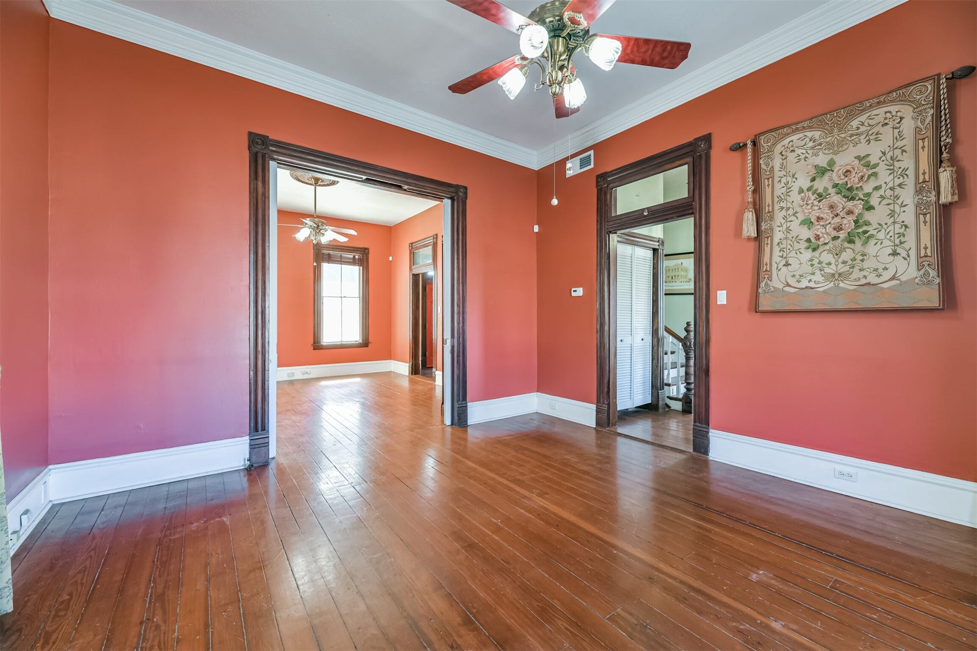 1927 Broadway Street, Galveston, TX 77550 The formal living space in the home is located just inside the front door. Notice the oversized crown molding and floorboards, beautiful original door casings, transom window, wood floors, lighted ceiling fan with a ceiling medallion, and pocket door access to the adjacent library/den.