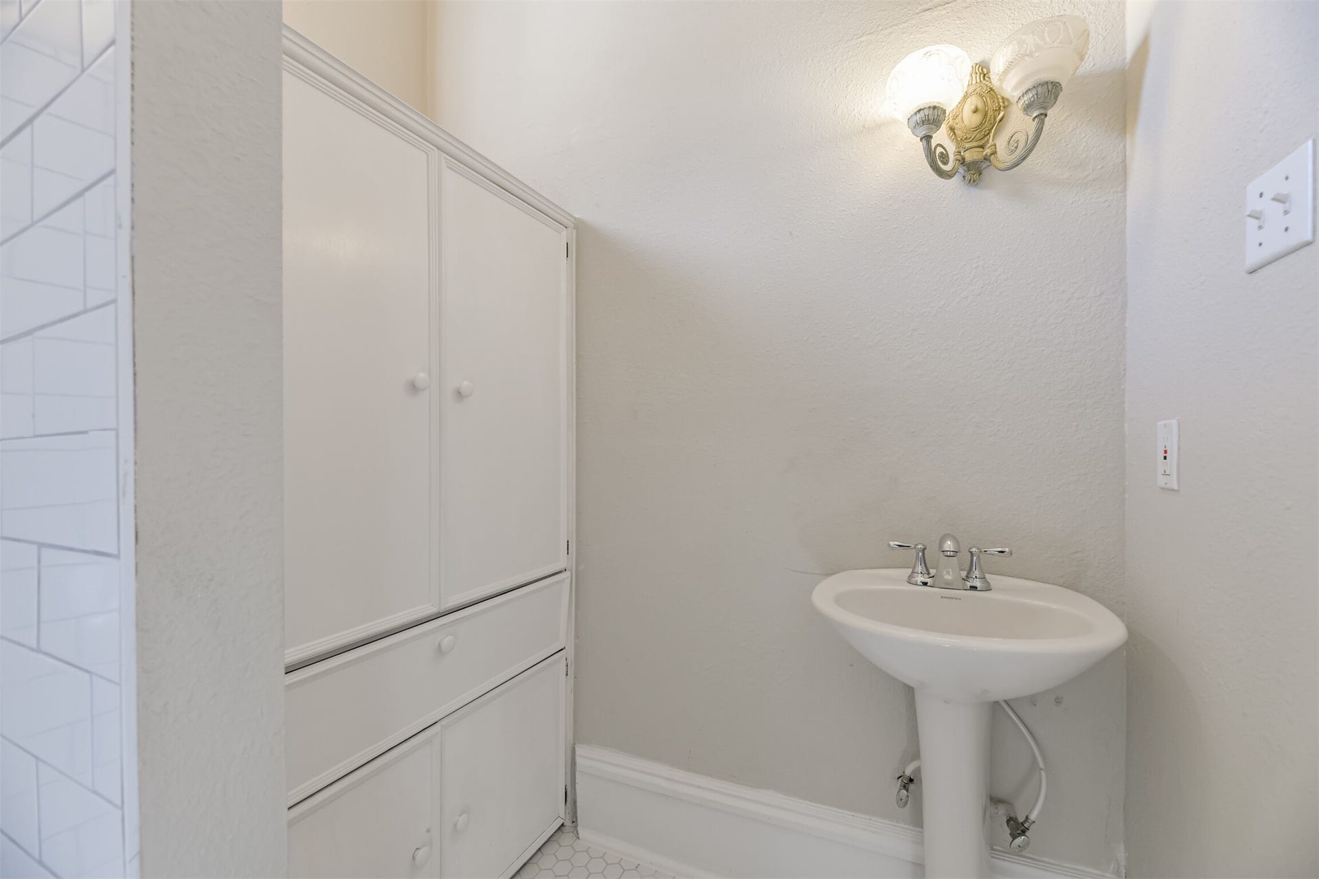 1927 Broadway Street, Galveston, TX 77550 An en suite master bathroom is a pretty extraordinary extravagance in a home from 1895, but this home has one! It features a pedestal sink, hexagonal tile floors, a walk-in shower, and a large built-in cabinet for storage.