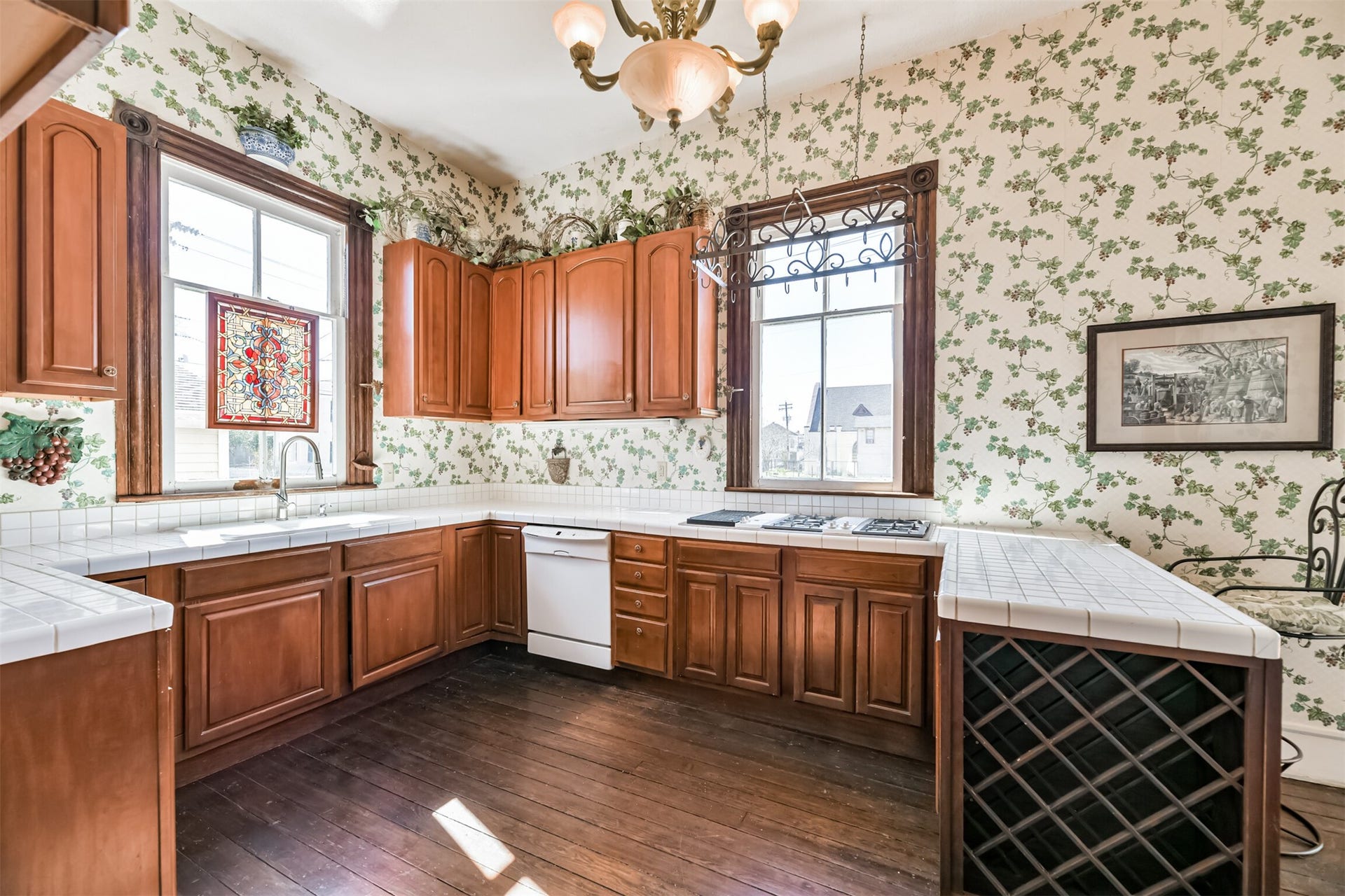 1927 Broadway Street, Galveston, TX 77550 Tucked near the rear of the home, with direct access to the dining room and back door, this kitchen features an abundance of cabinetry topped by classic white tile countertops. You'll even find a wine storage rack built-in!