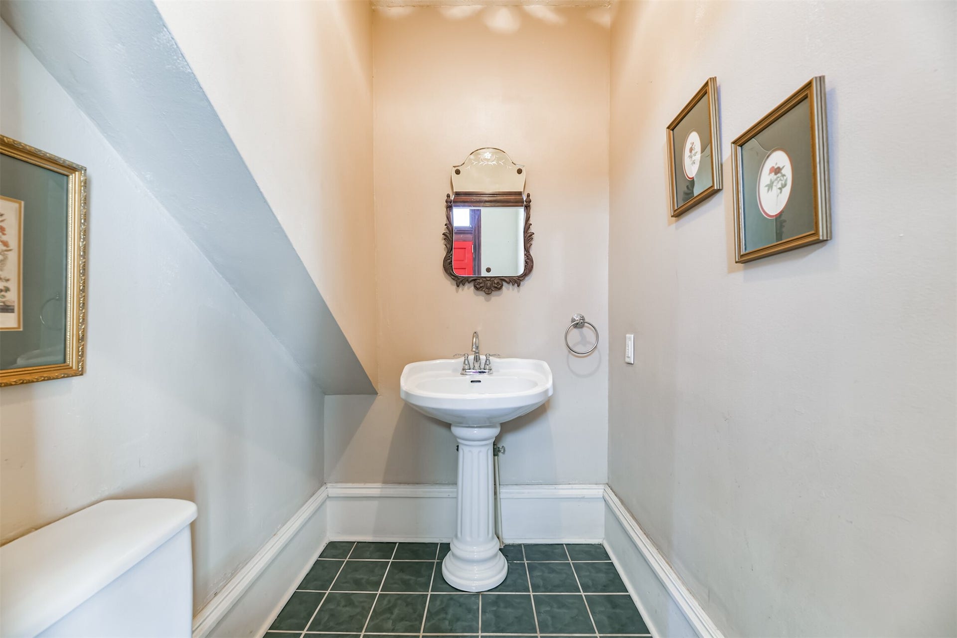 1927 Broadway Street, Galveston, TX 77550 With all bedrooms being on the upper levels, it is rare to find a home with a first-floor bathroom! This half bathroom with a pedestal sink is tucked between the kitchen and family room, near the entrance from the rear porch.