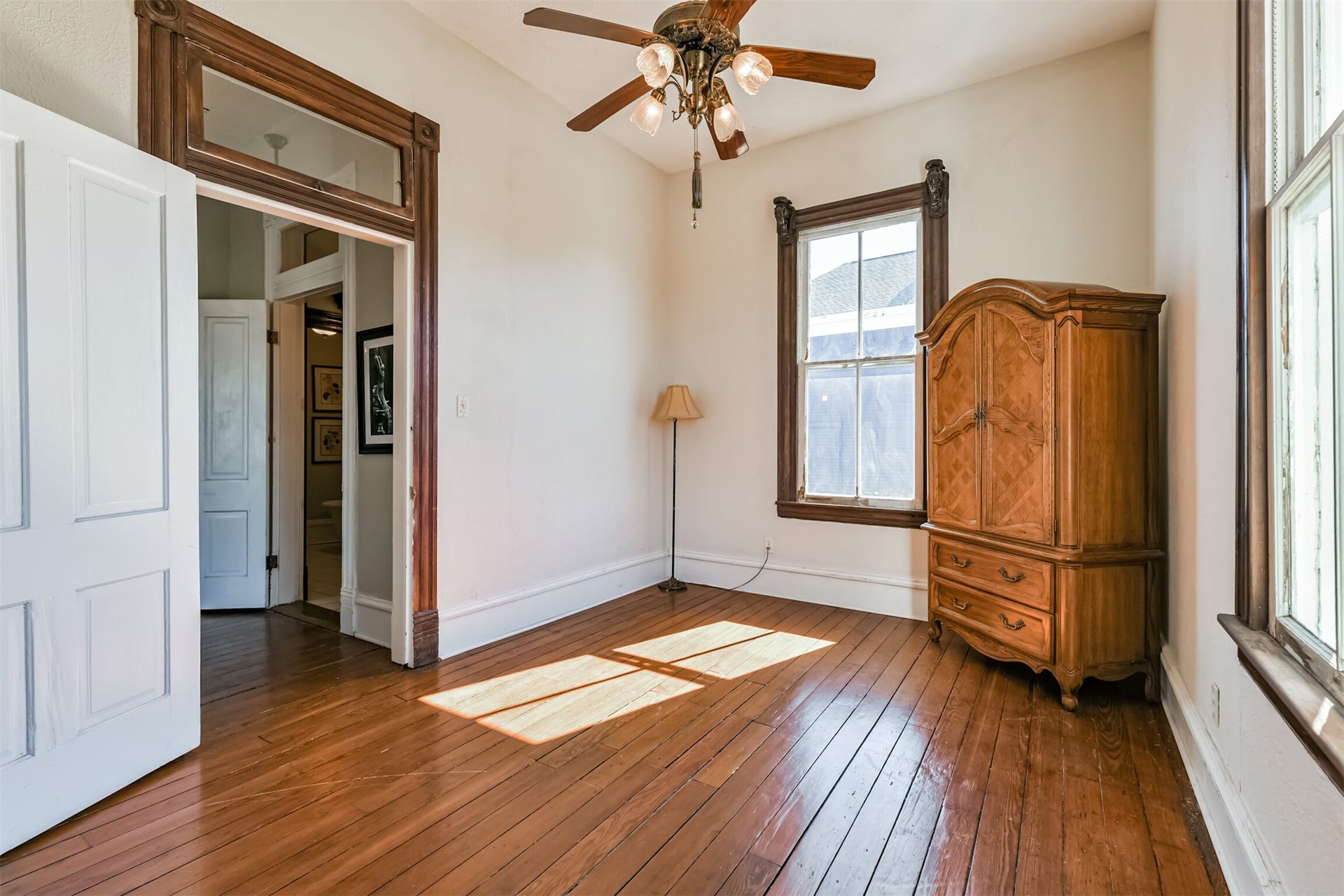 1927 Broadway Street, Galveston, TX 77550 Another secondary bedroom is adjacent to the previous room and just outside the door of the full bathroom. This bedroom offers a lighted ceiling fan, continued wood floors, ornately cased windows, and an original transom window above the door.