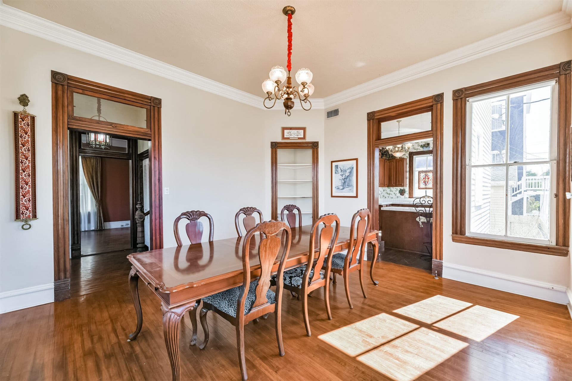 1927 Broadway Street, Galveston, TX 77550 To the right of the foyer and opposite the formal living room, this inviting dining room hosts exotic hardwood floors, original crown molding and trim work, a built-in corner nook, and an abundance of light shining in through numerous cased windows.