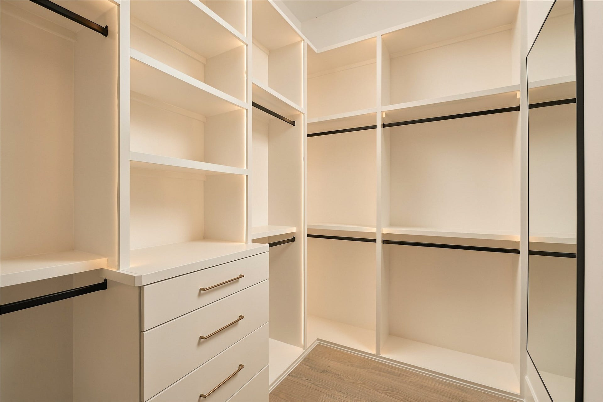 2107 McKean Drive, Houston, TX 77080 One of two dedicated custom closets in the primary suite offers extensive built-in shelving, drawers, and hanging space, complemented by integrated LED lighting.