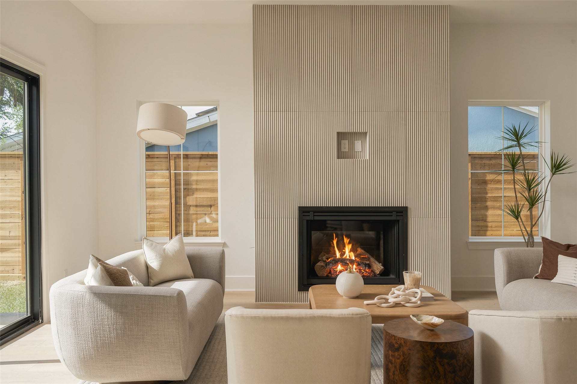2107 McKean Drive, Houston, TX 77080 The dining and living spaces flow together beneath 11-foot ceilings, while expansive glass doors draw the eye toward the covered patio and backyard beyondcreating a seamless setting for indoor-outdoor entertaining.