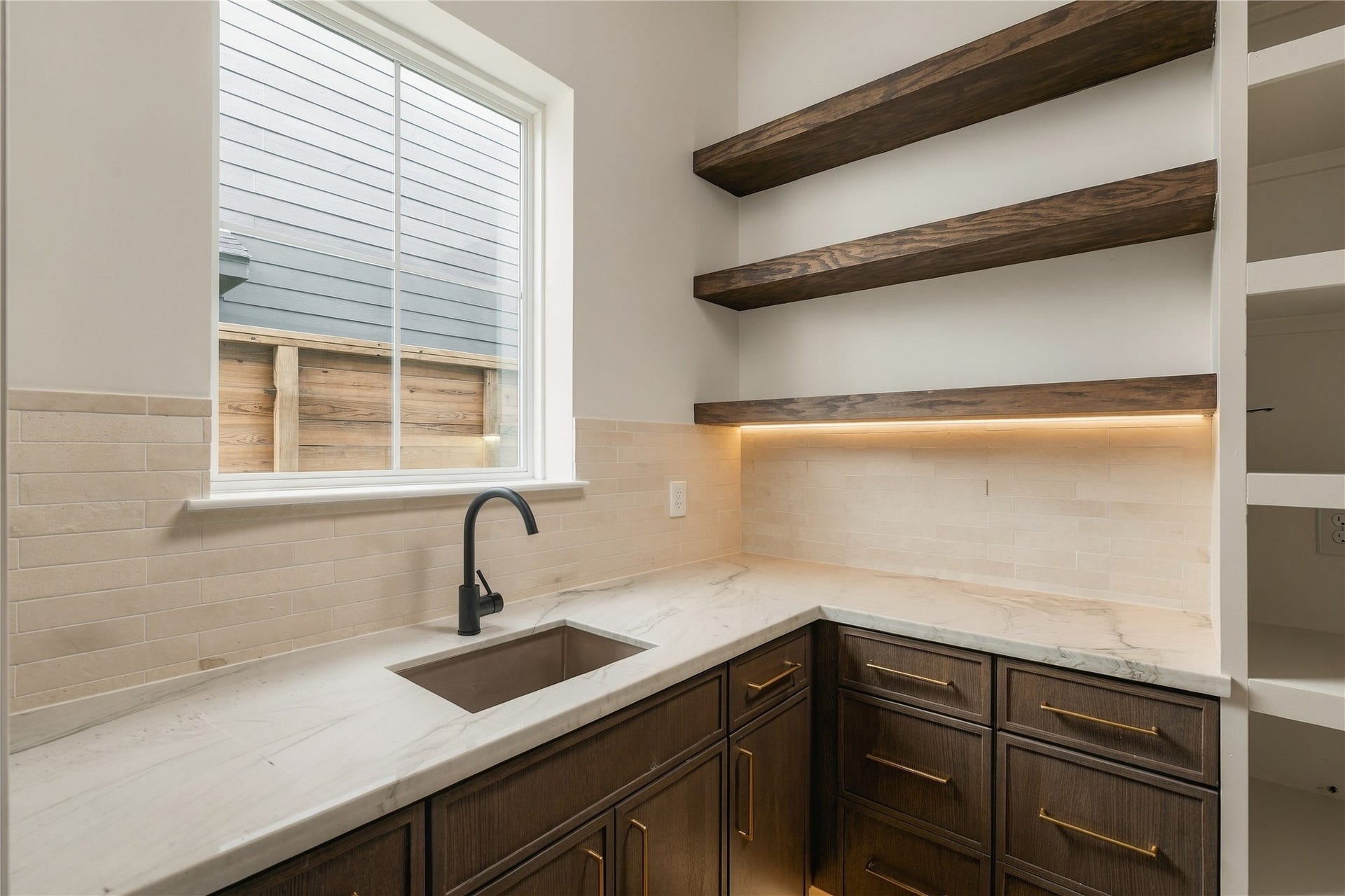 2107 McKean Drive, Houston, TX 77080 A discreet scullery-style pantry extends the kitchens functionality with generous prep space, additional cabinetry, open white oak shelving, and its own sinkkeeping the main kitchen ready for entertaining.